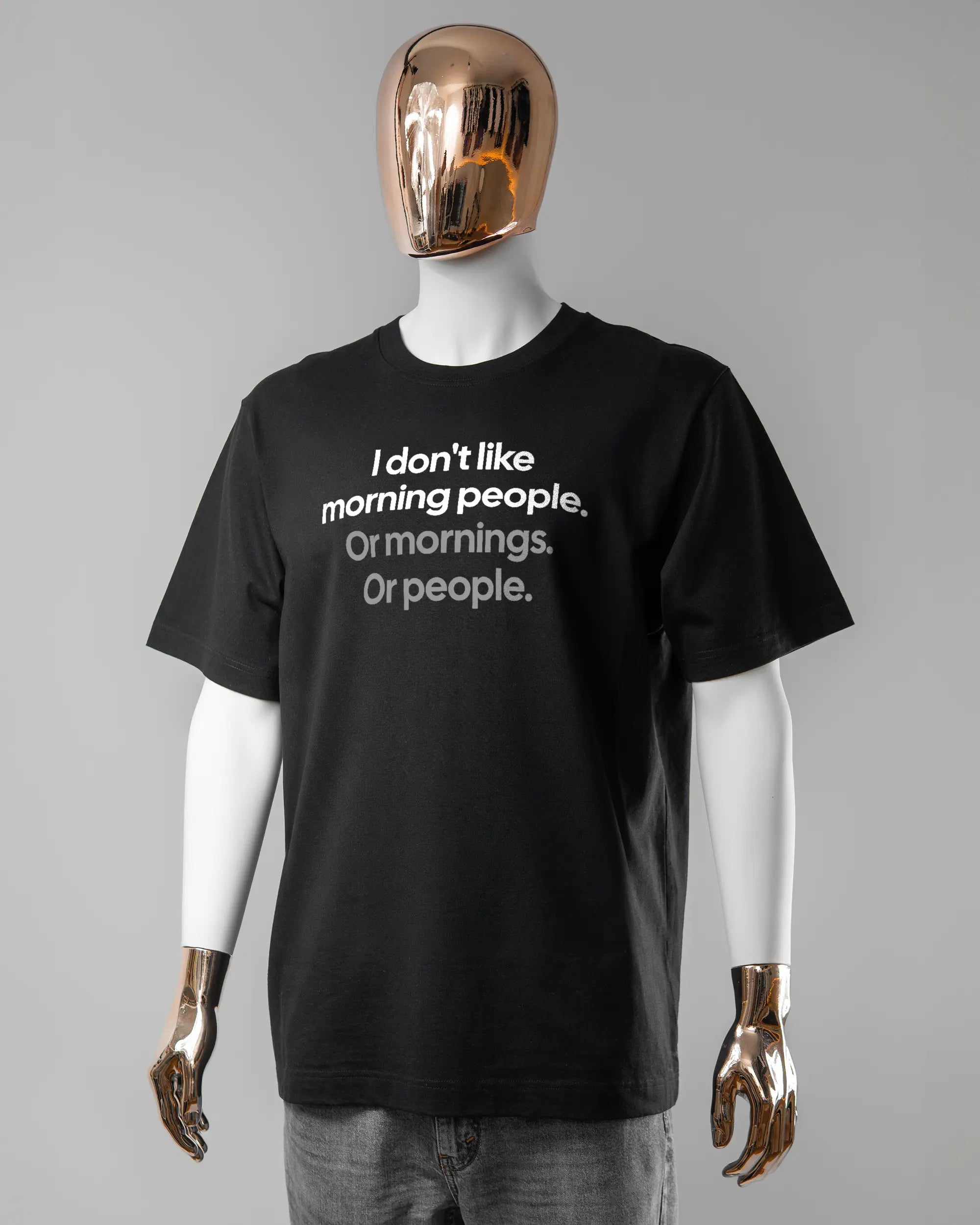 Vorderseite des Organic Unisex T-Shirt Heavy Oversized von Maondo mit dem Design Morning Person in der Farbe Black und in der Größe L getragen von einer maskulinen Puppe