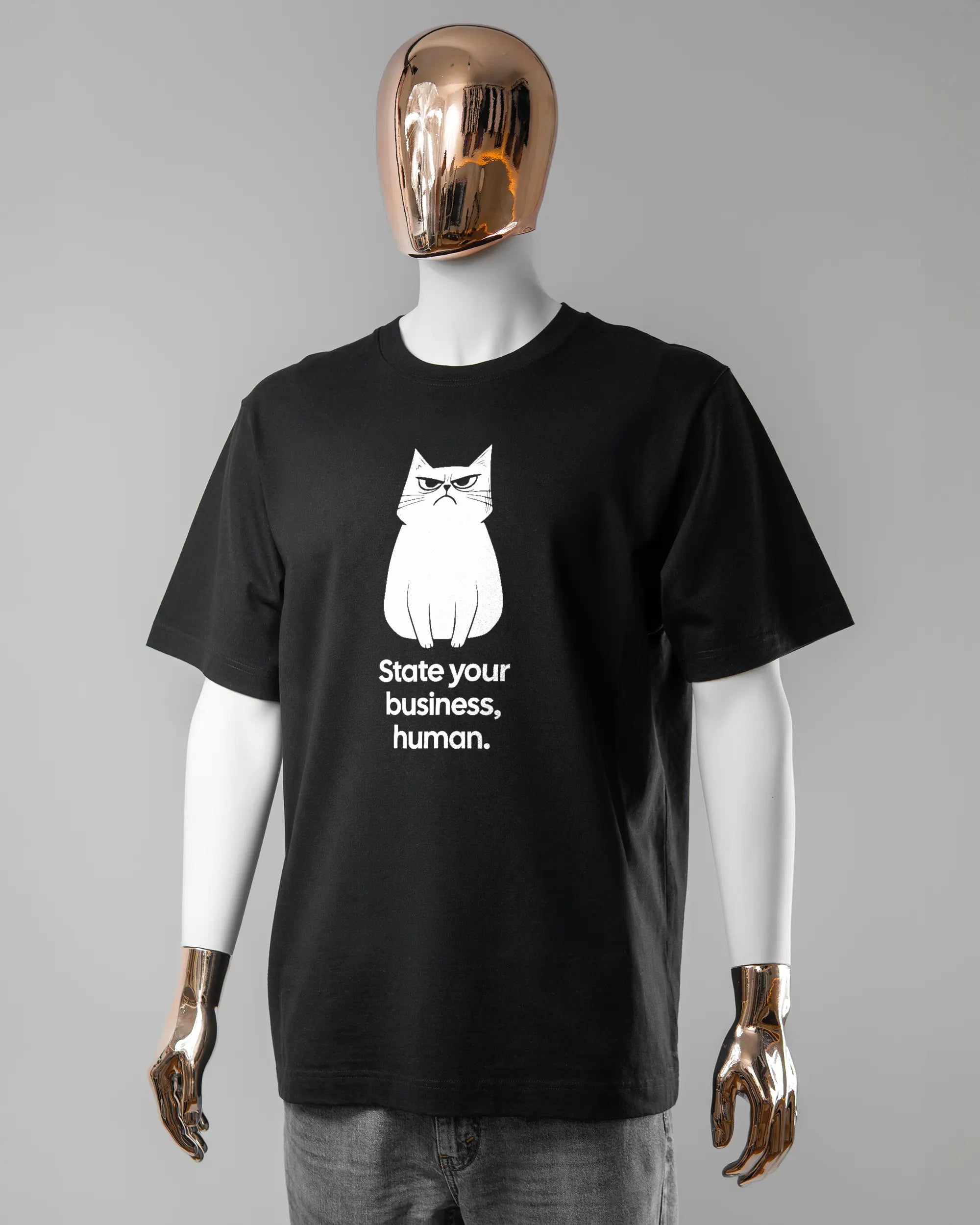 Vorderseite des Organic Unisex T-Shirt Heavy Oversized von Maondo mit dem Design Grumpy Purr in der Farbe Black und in der Größe L getragen von einer maskulinen Puppe