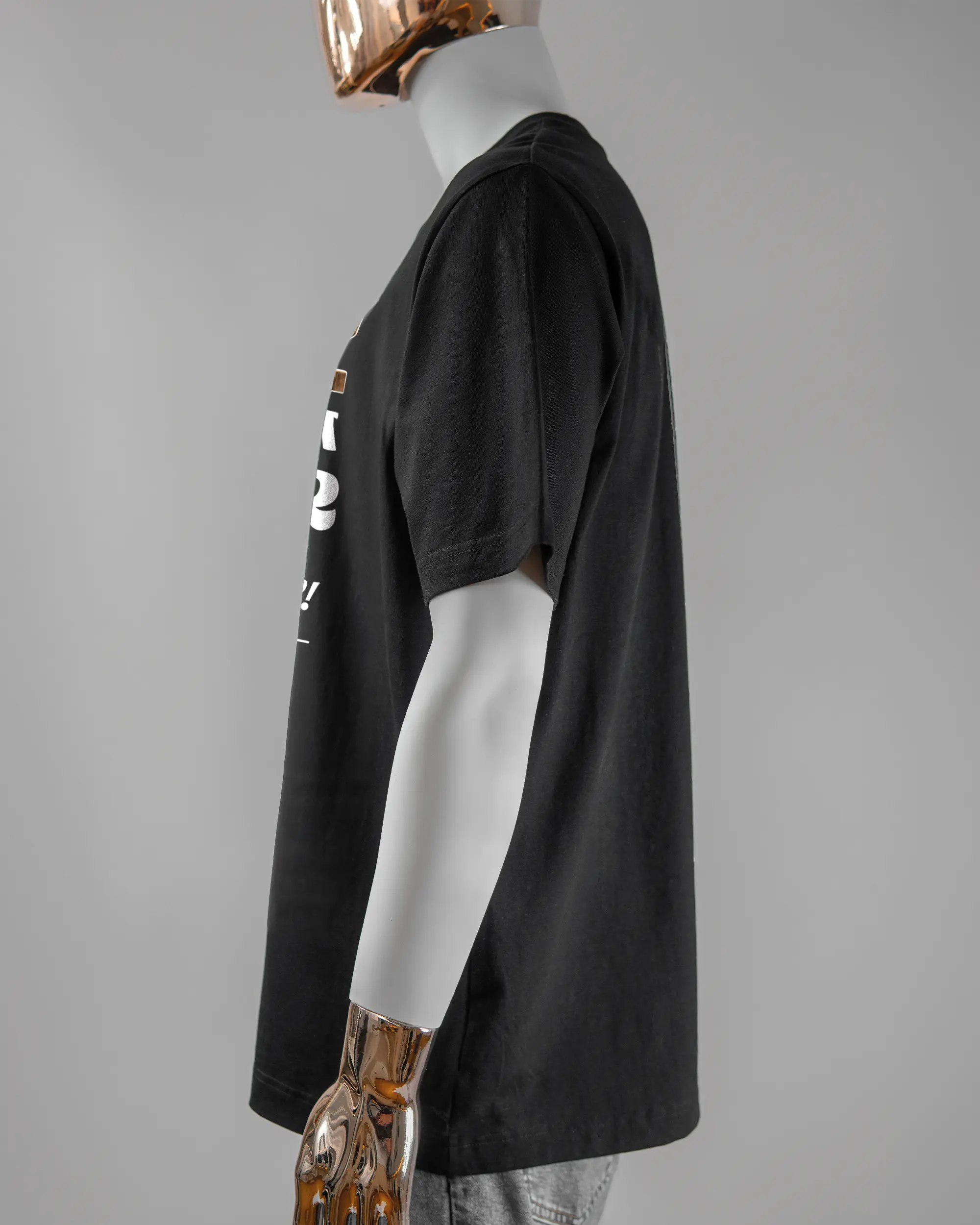 Seitenansicht des Organic Unisex T-Shirt Heavy Oversized von Maondo mit dem Design Holzarbeit vorne in der Farbe Black und in der Größe L getragen von einer maskulinen Puppe
