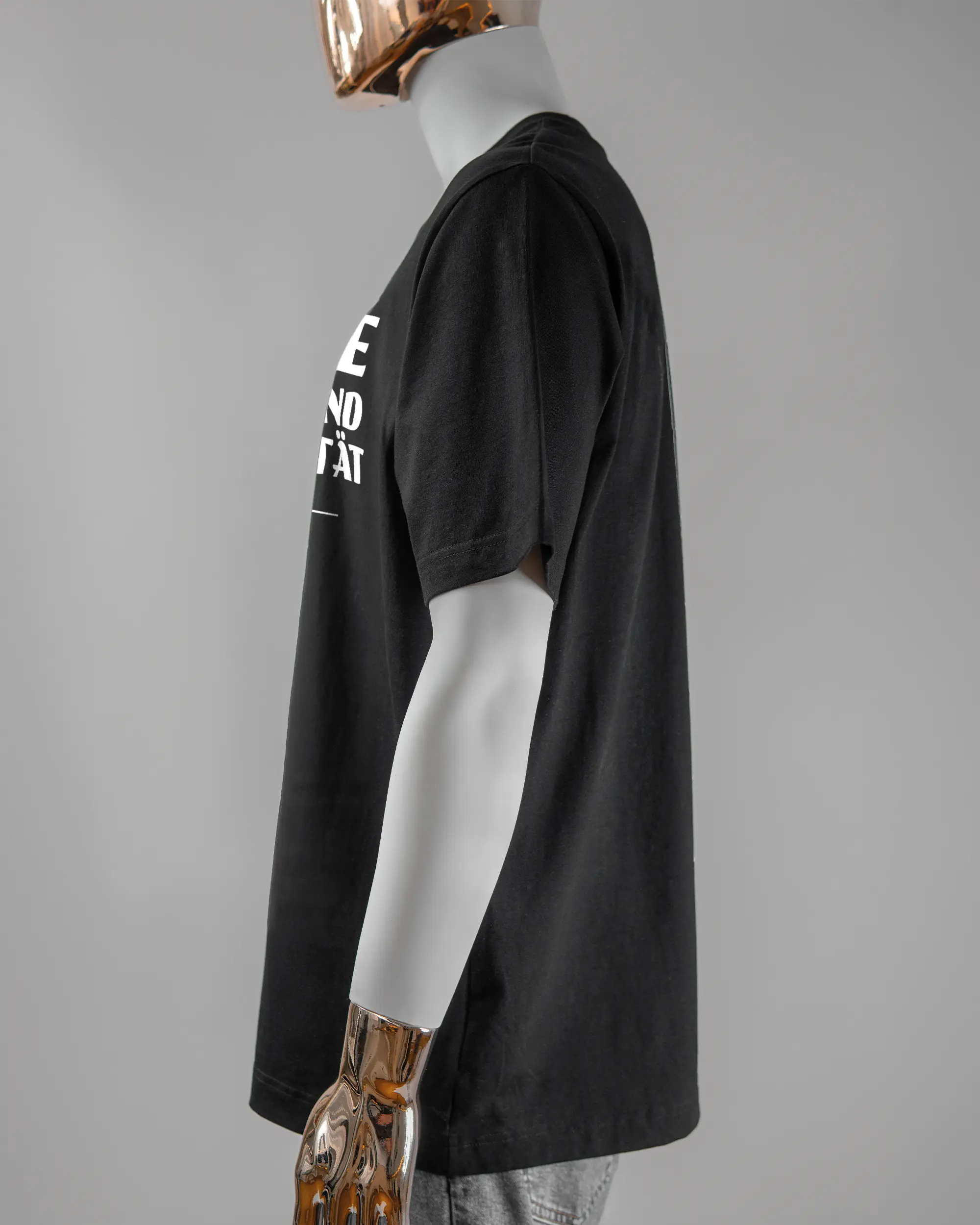 Seitenansicht des Organic Unisex T-Shirt Heavy Oversized von Maondo mit dem Design Keine Eile vorne in der Farbe Black und in der Größe L getragen von einer maskulinen Puppe