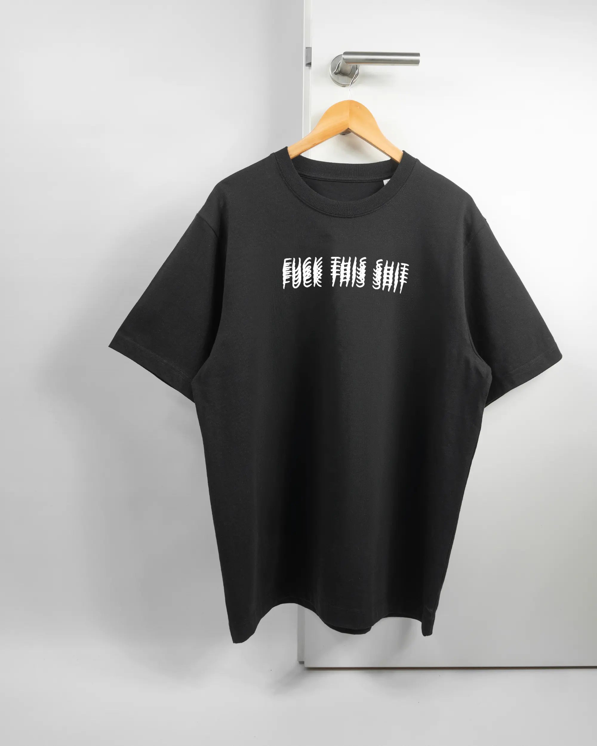 Vorderseite des Organic Unisex T-Shirt Heavy Oversized von Maondo mit dem Design Hidden Message in der Farbe Black und in der Größe L auf einem Bügel an der Türklinke aufgehängt