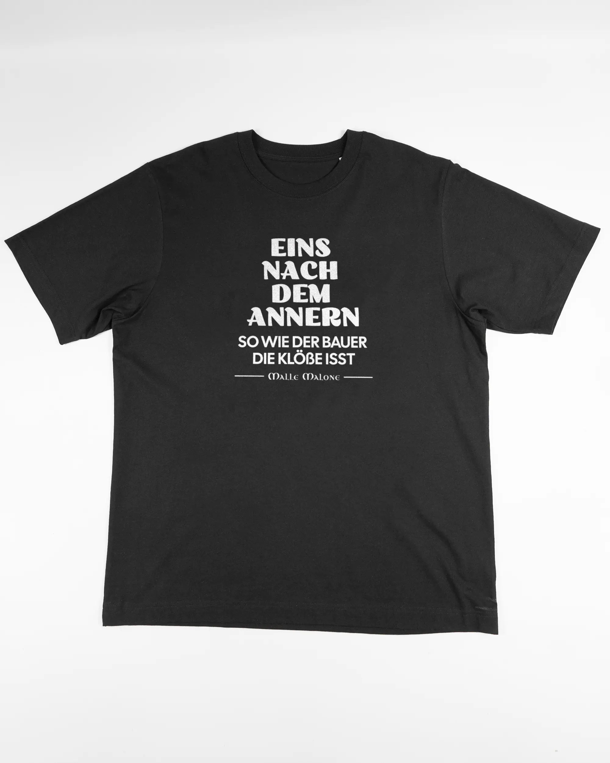Vorderseite des Organic Unisex T-Shirt Heavy Oversized von Maondo mit dem Design Eins nach dem Annern in der Farbe Black und in der Größe L flach auf den Boden gelegt