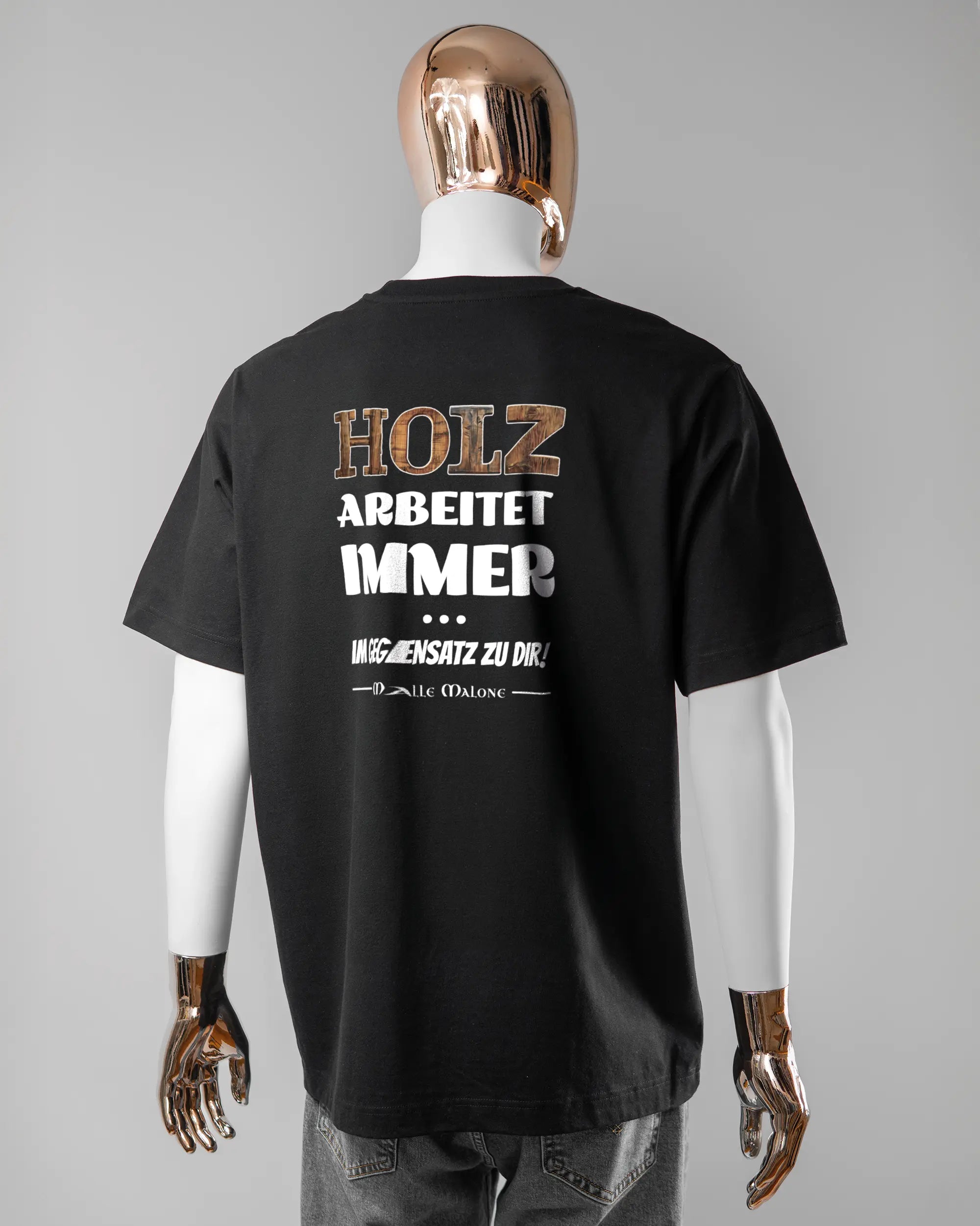 Rückseite des Organic Unisex T-Shirt Heavy Oversized von Maondo mit dem Design Holzarbeit in der Farbe Black und in der Größe L getragen von einer maskulinen Puppe