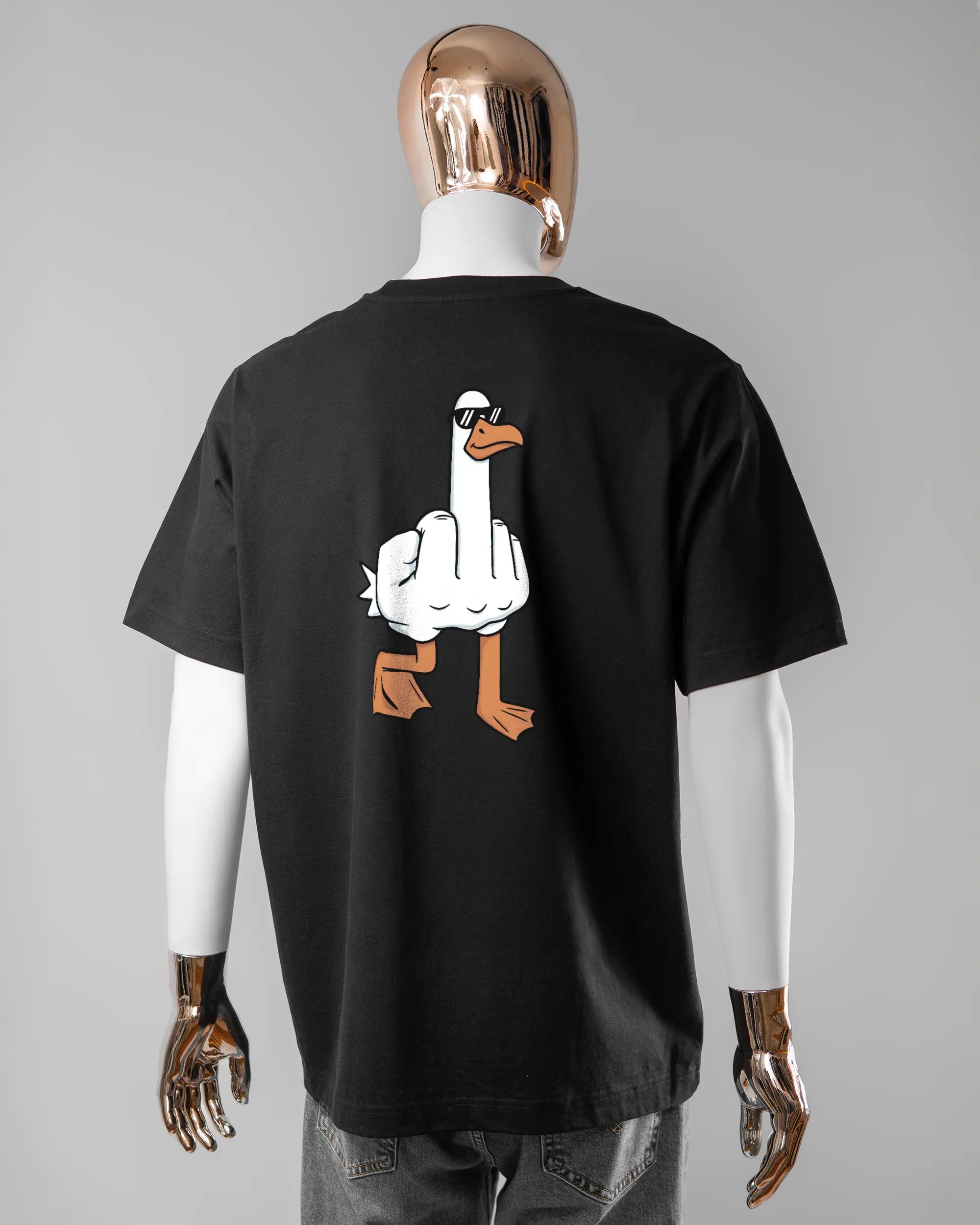Rückseite des Organic Unisex T-Shirt Heavy Oversized von Maondo mit dem Design I give a duck in der Farbe Black und in der Größe L getragen von einer maskulinen Puppe