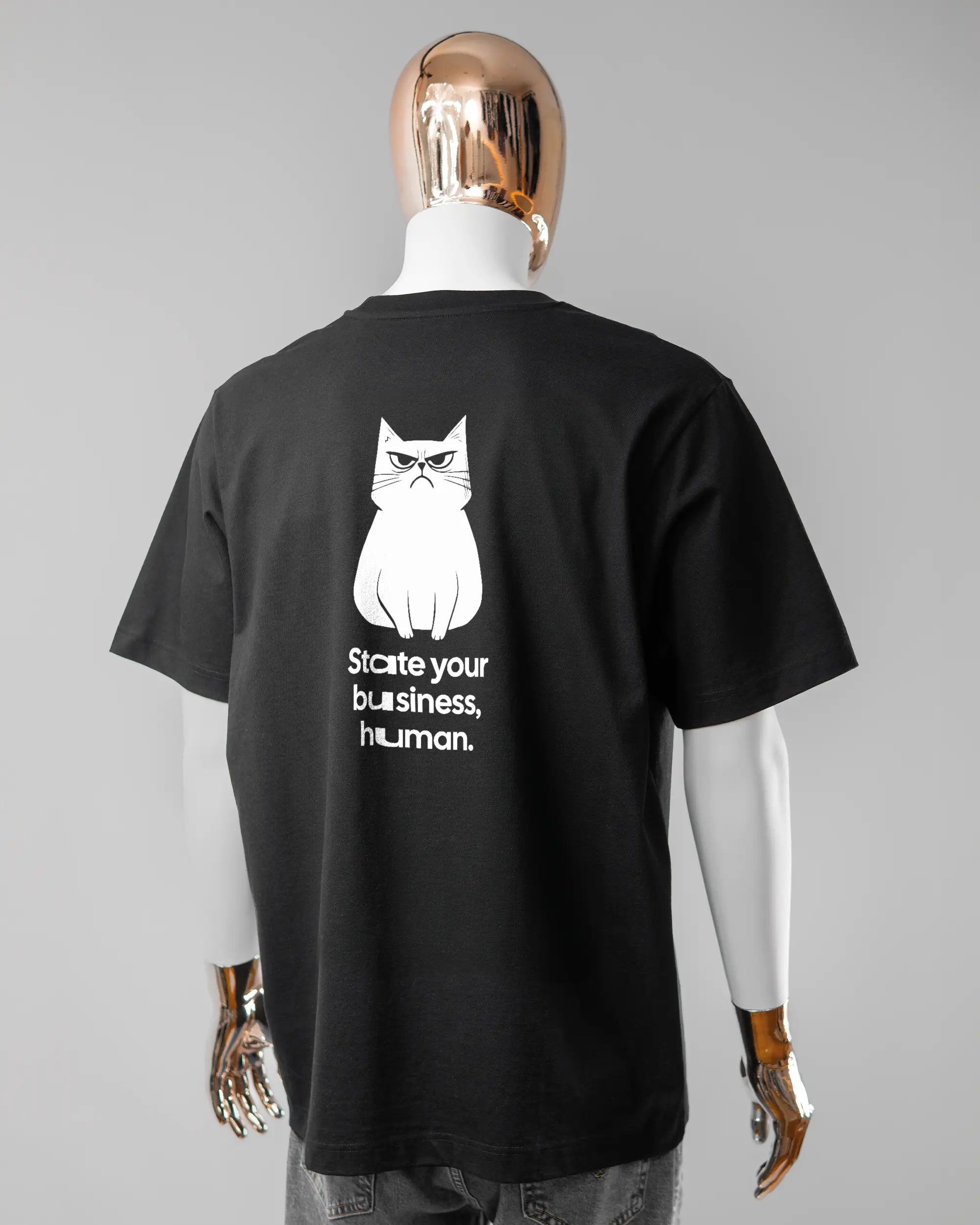 Rückseite des Organic Unisex T-Shirt Heavy Oversized von Maondo mit dem Design Grumpy Purr in der Farbe Black und in der Größe L getragen von einer maskulinen Puppe
