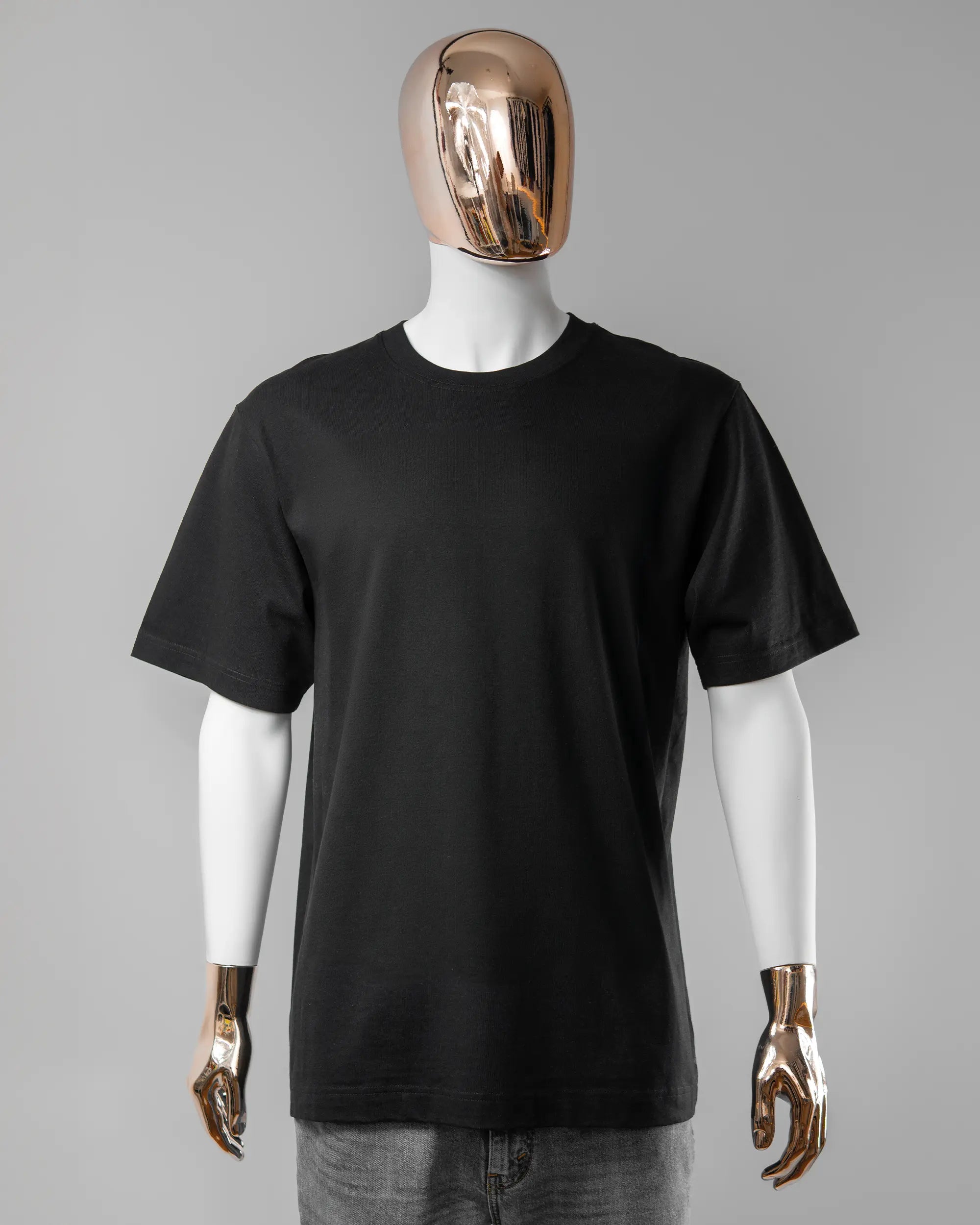 Vorderseite des Organic Unisex T-Shirt Heavy Oversized von Maondo ohne Motiv in der Farbe Black und in der Größe L getragen von einer maskulinen Puppe