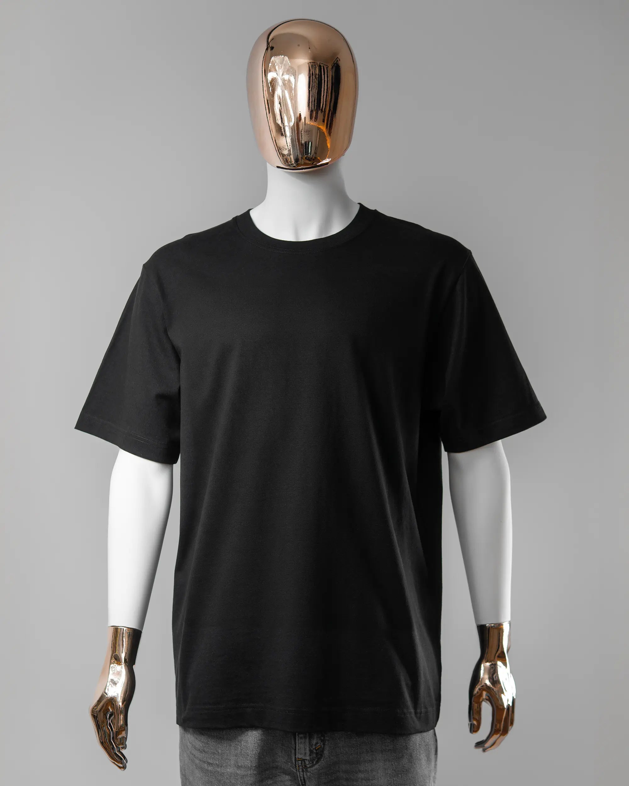 Vorderseite des Organic Unisex T-Shirt Heavy Oversized von Maondo ohne Motiv in der Farbe Black und in der Größe L getragen von einer maskulinen Puppe