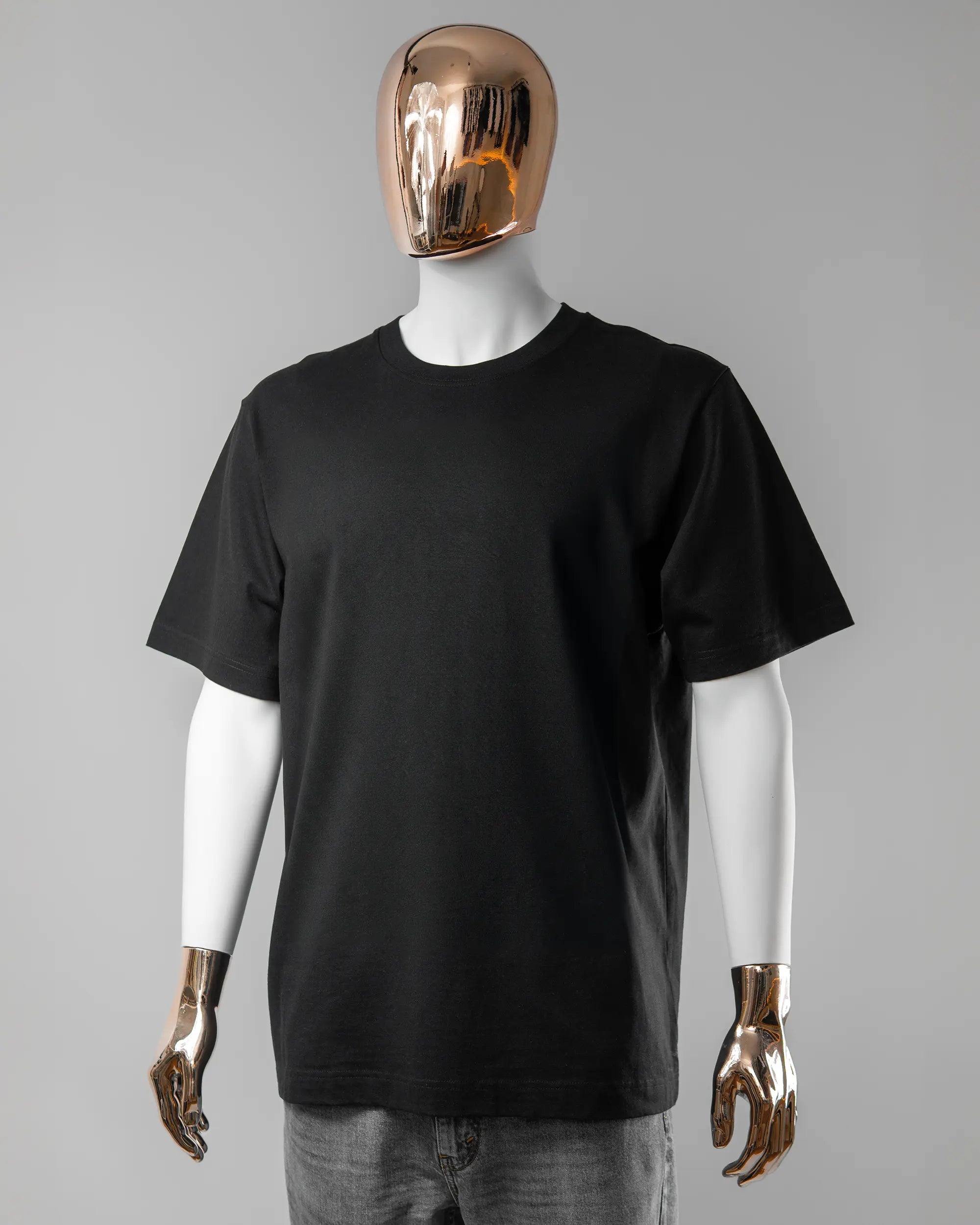 Vorderseite des Organic Unisex T-Shirt Heavy Oversized von Maondo ohne Motiv in der Farbe Black und in der Größe L getragen von einer maskulinen Puppe