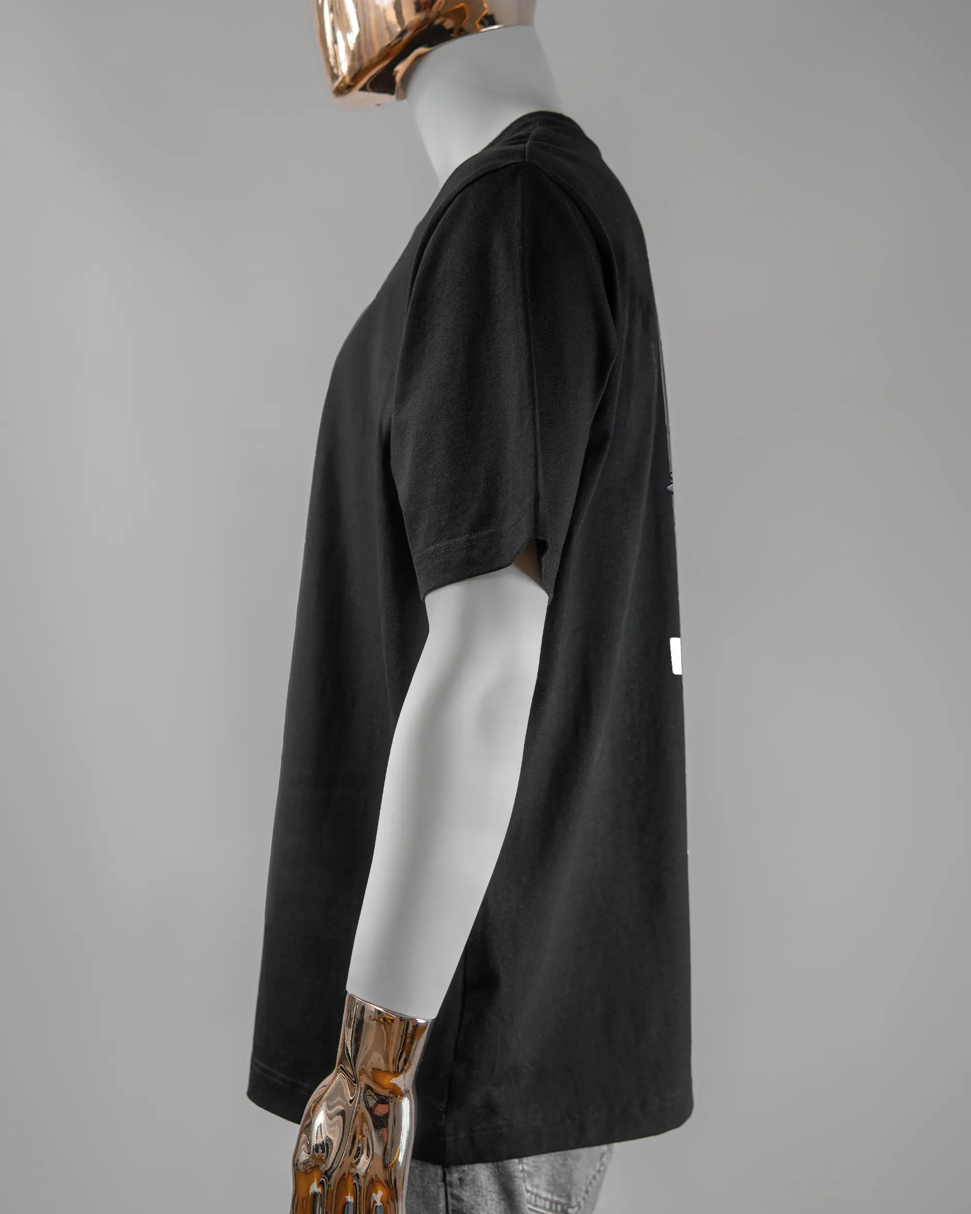 Seitenansicht des Organic Unisex T-Shirt Heavy Oversized von Maondo mit dem Design Pigeon Pun hinten in der Farbe Black und in der Größe L getragen von einer maskulinen Puppe