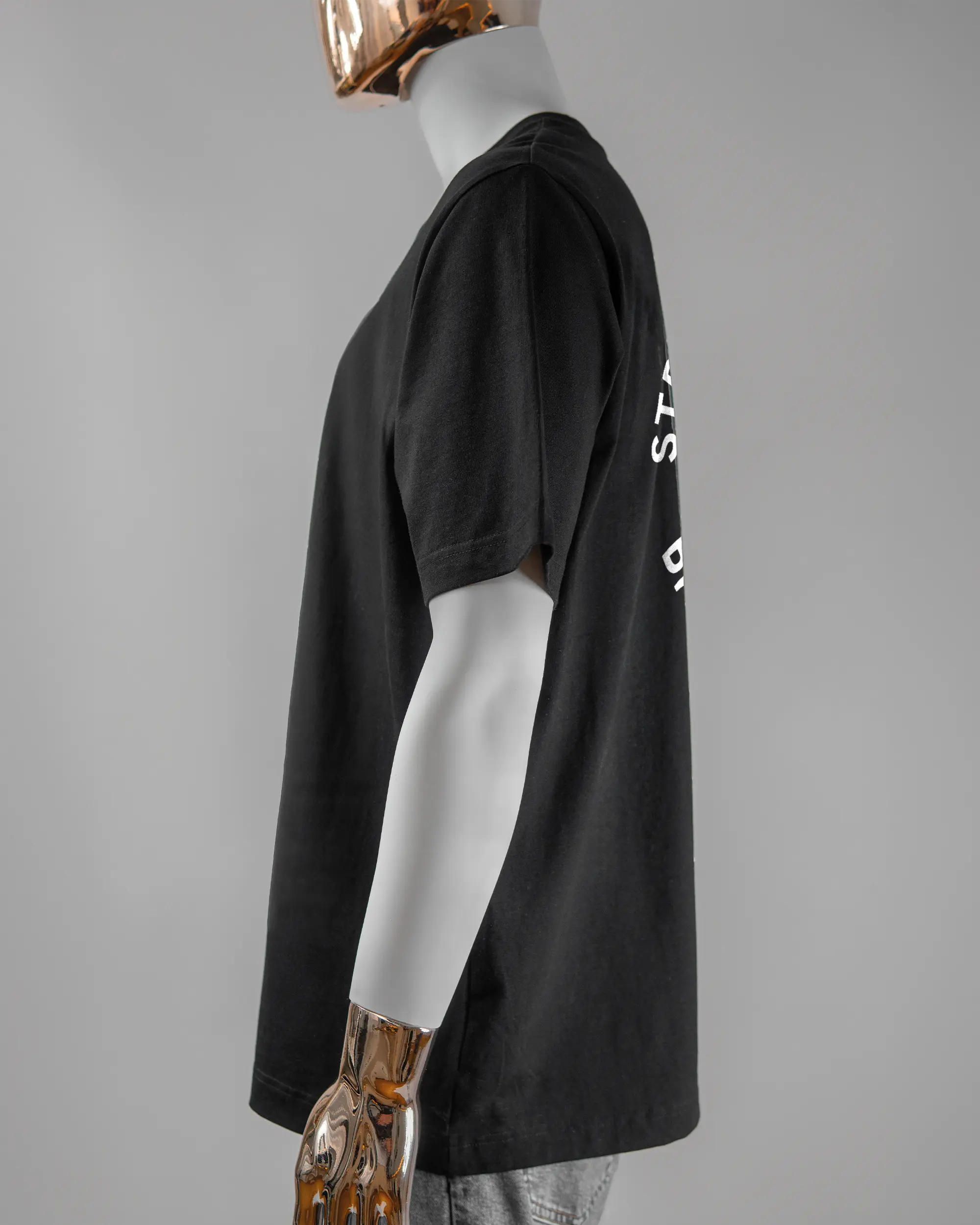 Seitenansicht des Organic Unisex T-Shirt Heavy Oversized von Maondo mit dem Design Brocco-Lee hinten in der Farbe Black und in der Größe L getragen von einer maskulinen Puppe