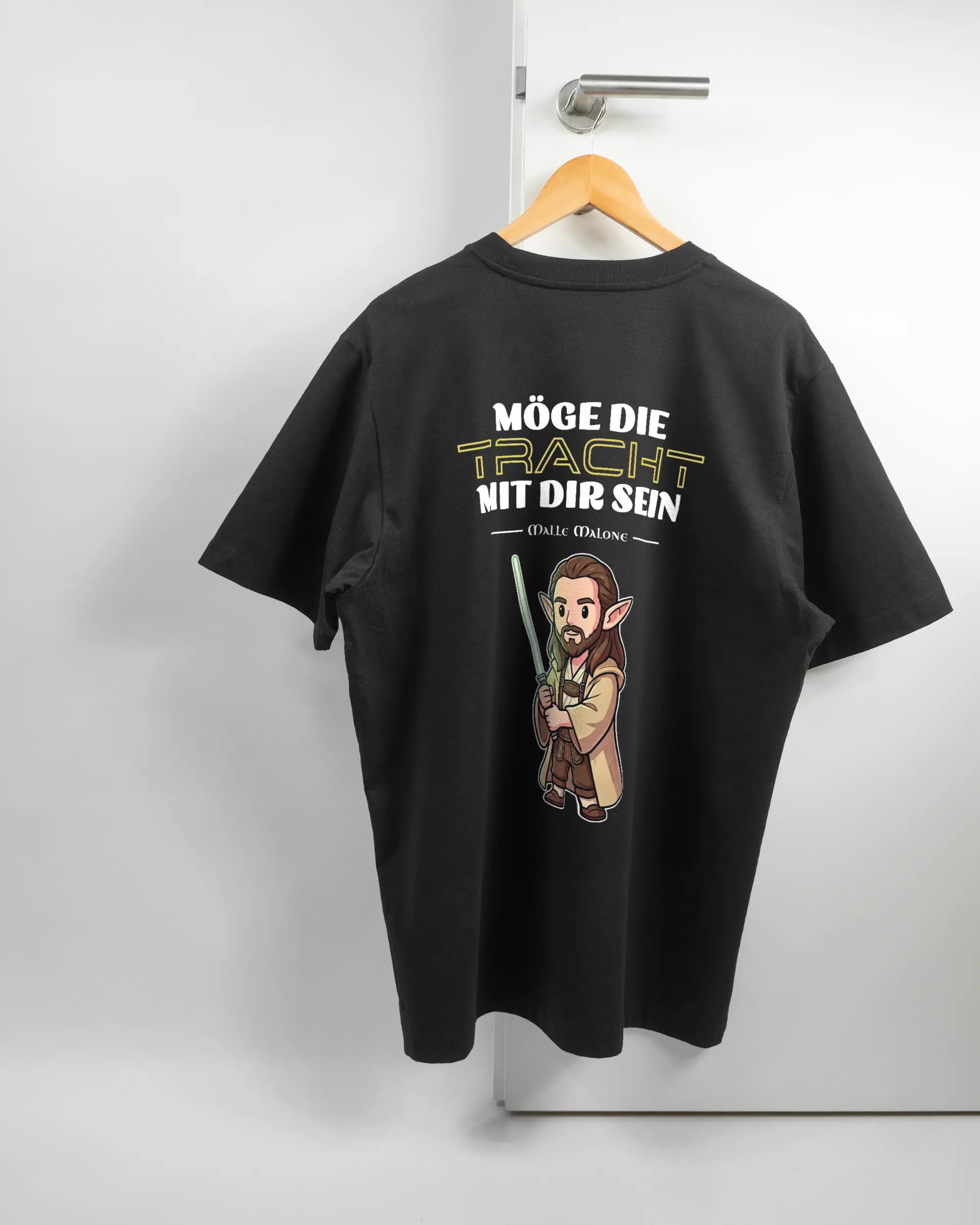 Rückseite des Organic Unisex T-Shirt Heavy Oversized von Maondo mit dem Design Tracht mit dir in der Farbe Black und in der Größe L auf einem Bügel an der Türklinke aufgehängt