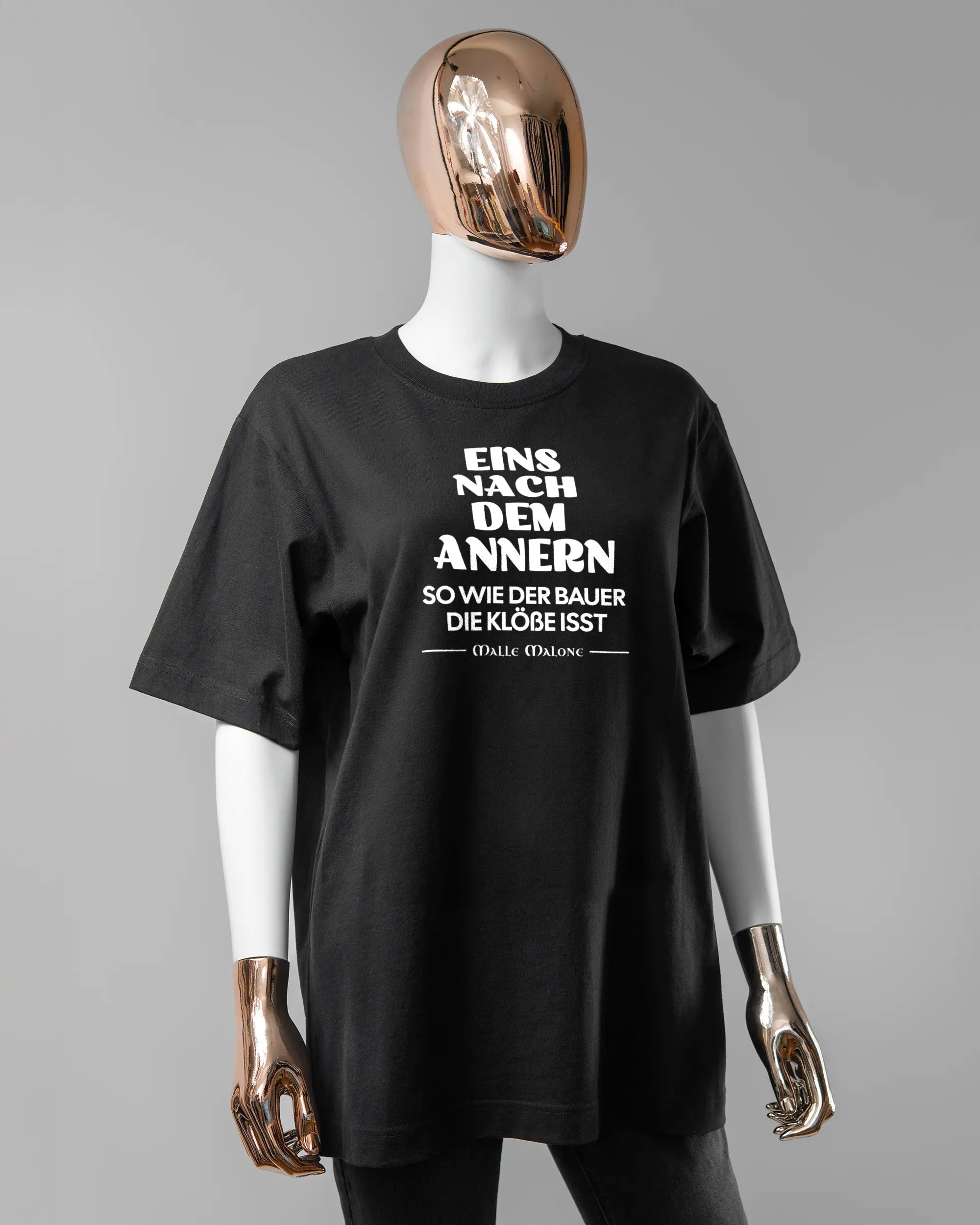 Vorderseite des Organic Unisex T-Shirt Heavy Oversized von Maondo mit dem Design Eins nach dem Annern in der Farbe Black und in der Größe S getragen von einer femininen Puppe