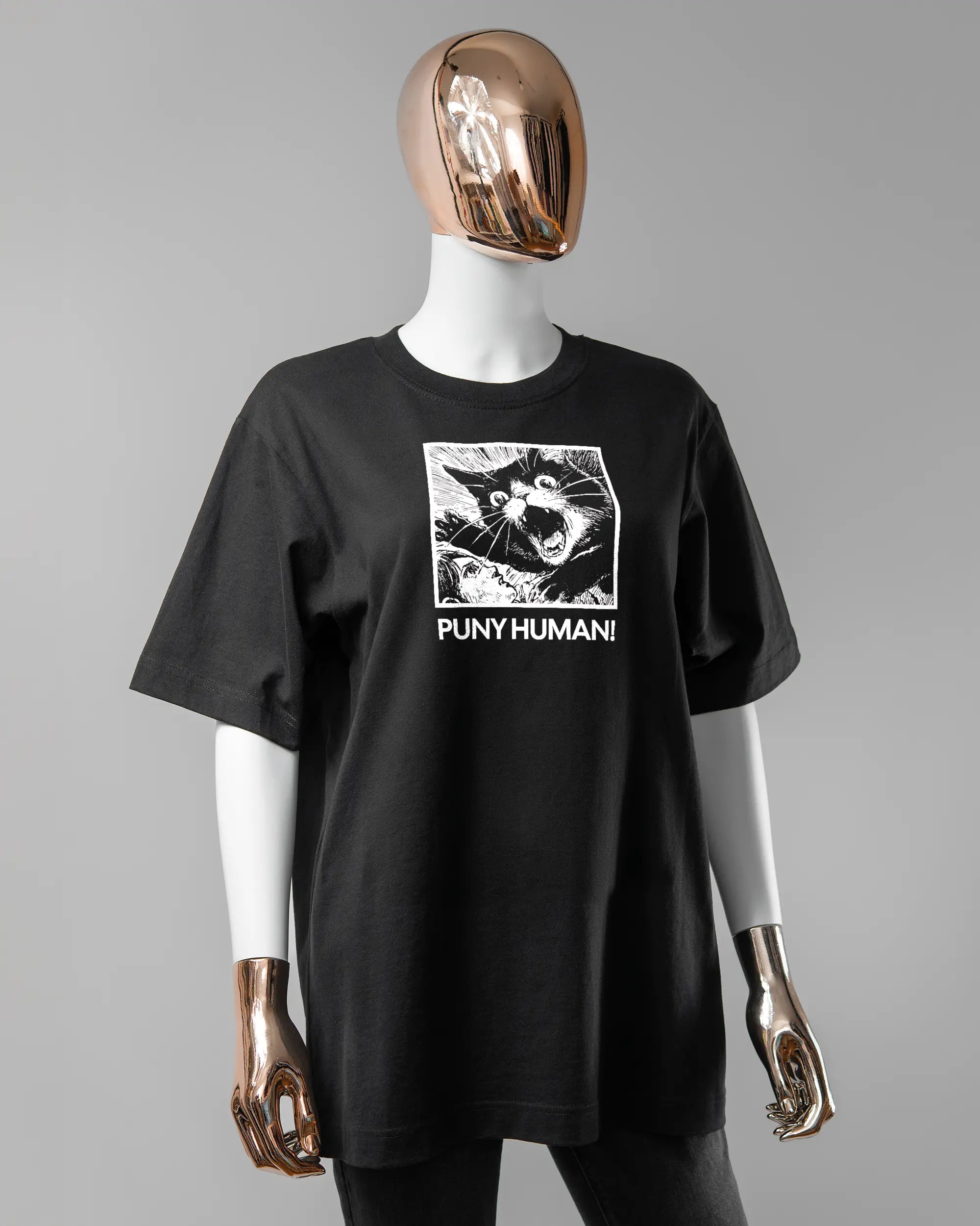 Vorderseite des Organic Unisex T-Shirt Heavy Oversized von Maondo mit dem Design Puny Human in der Farbe Black und in der Größe S getragen von einer femininen Puppe