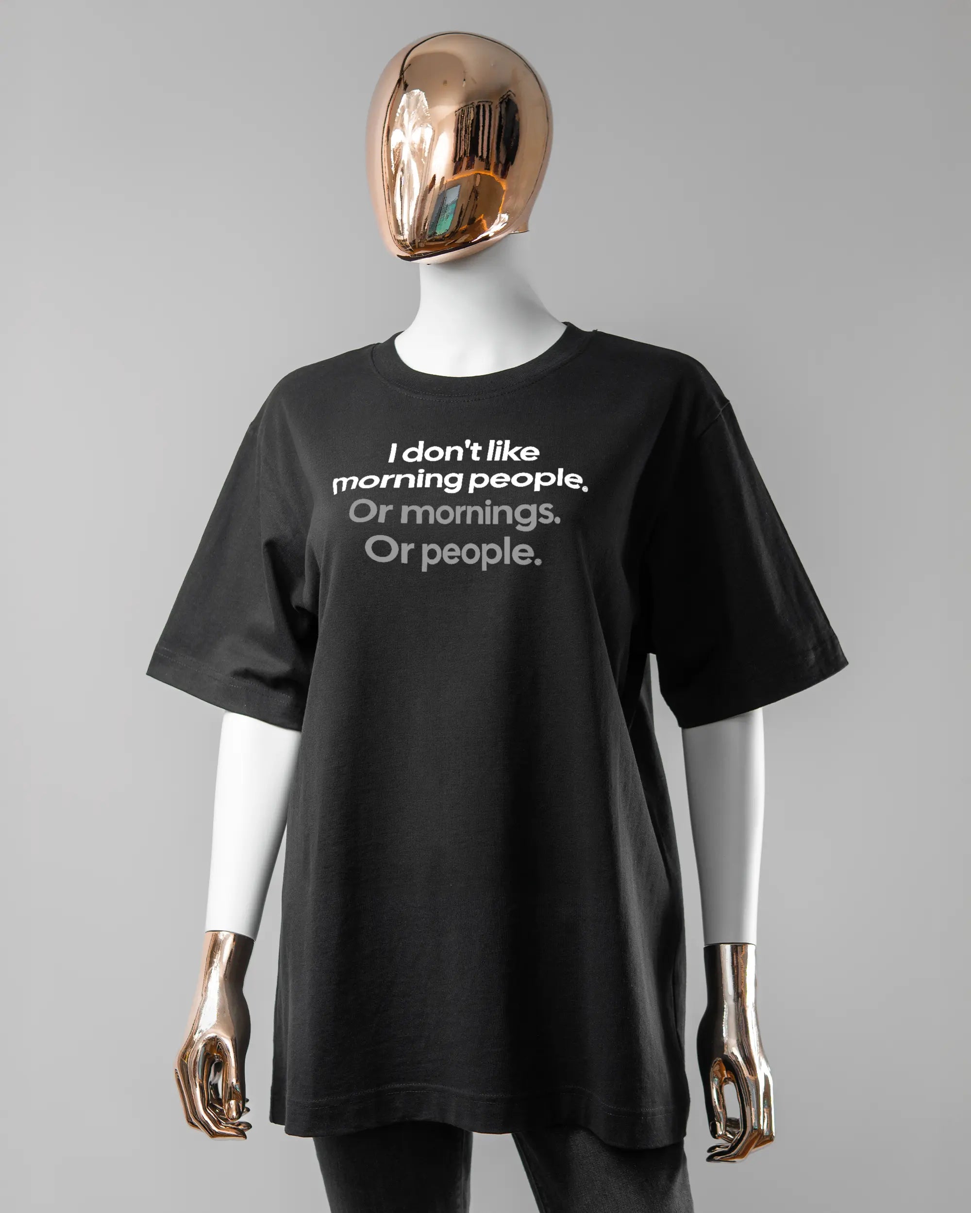 Vorderseite des Organic Unisex T-Shirt Heavy Oversized von Maondo mit dem Design Morning Person in der Farbe Black und in der Größe S getragen von einer femininen Puppe