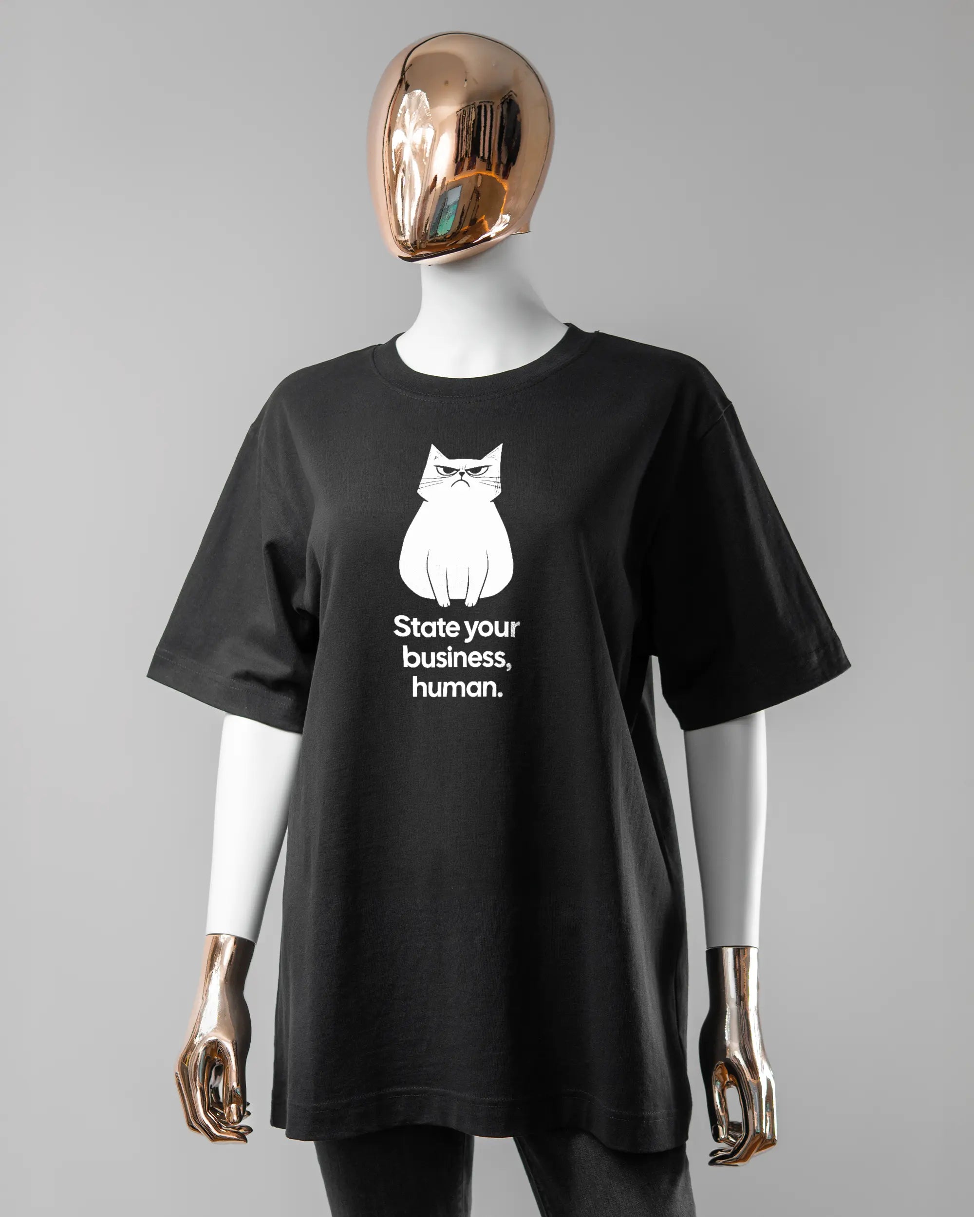 Vorderseite des Organic Unisex T-Shirt Heavy Oversized von Maondo mit dem Design Grumpy Purr in der Farbe Black und in der Größe S getragen von einer femininen Puppe