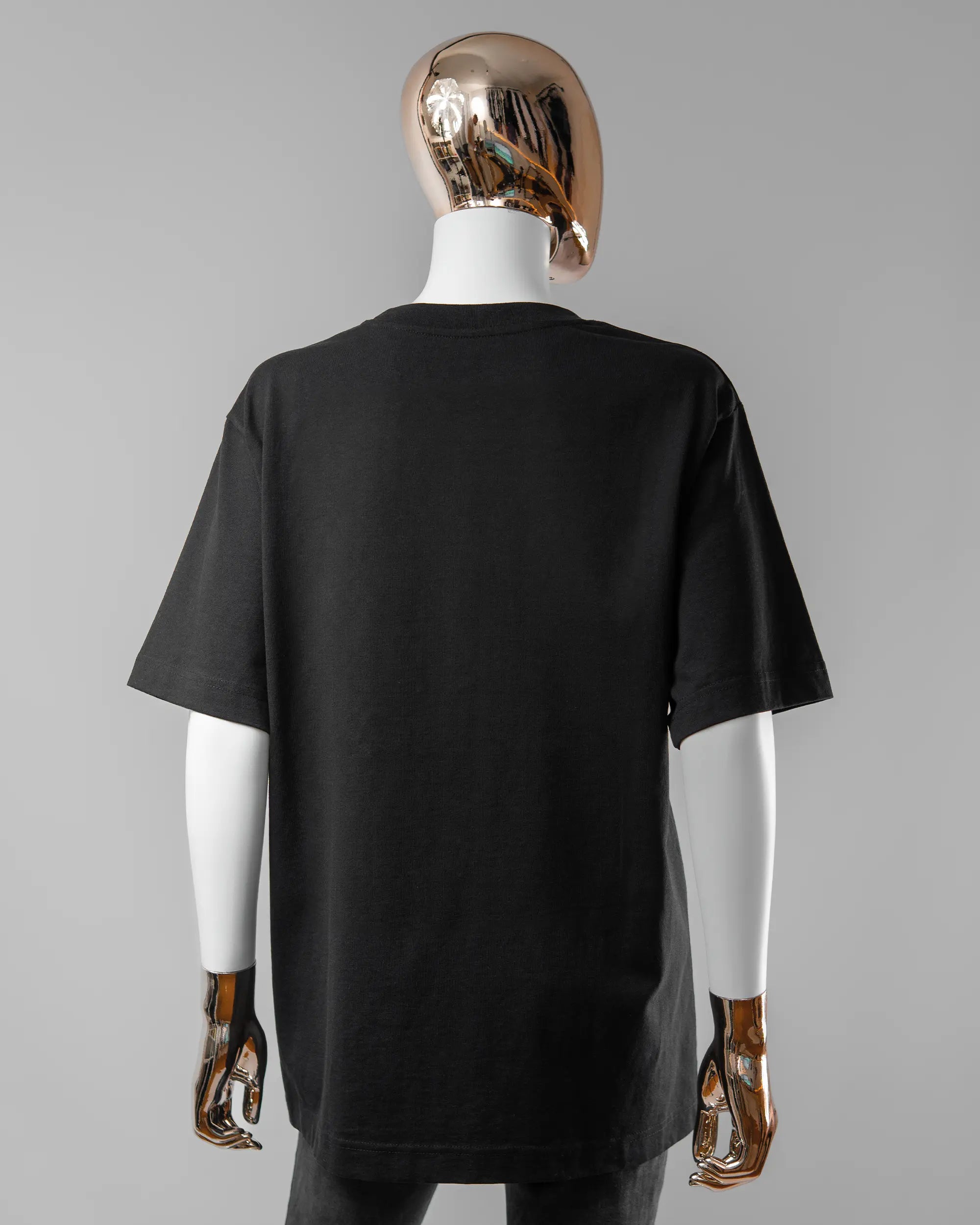 Rückseite des Organic Unisex T-Shirt Heavy Oversized von Maondo ohne Motiv in der Farbe Black und in der Größe S getragen von einer femininen Puppe