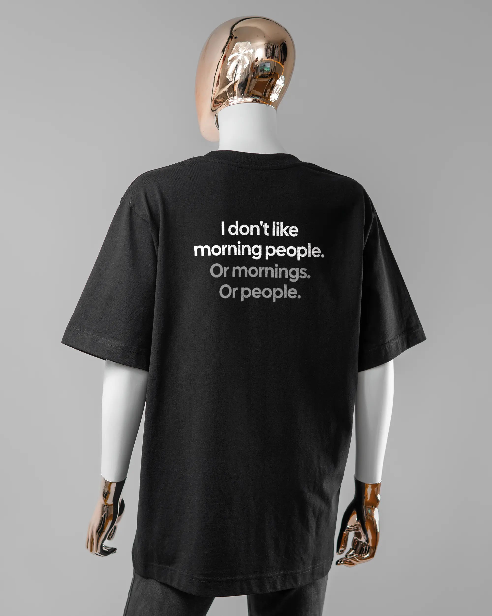 Rückseite des Organic Unisex T-Shirt Heavy Oversized von Maondo mit dem Design Morning Person in der Farbe Black und in der Größe S getragen von einer femininen Puppe