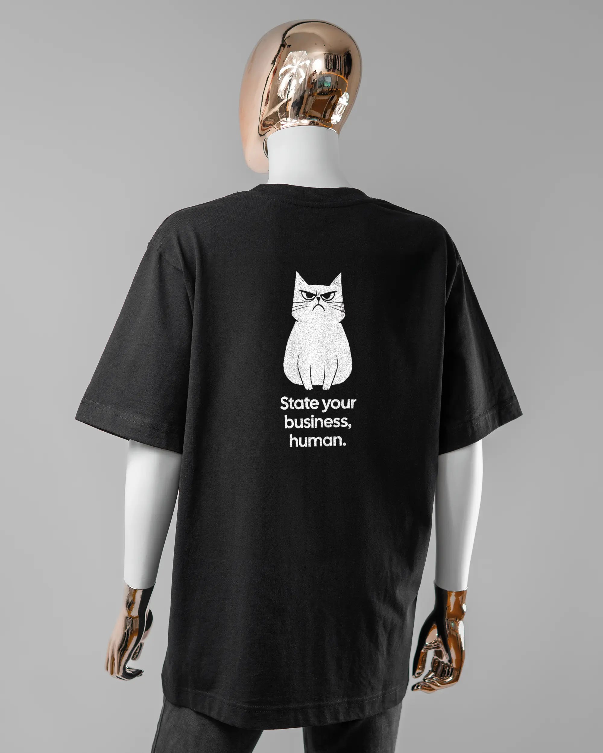 Rückseite des Organic Unisex T-Shirt Heavy Oversized von Maondo mit dem Design Grumpy Purr in der Farbe Black und in der Größe S getragen von einer femininen Puppe