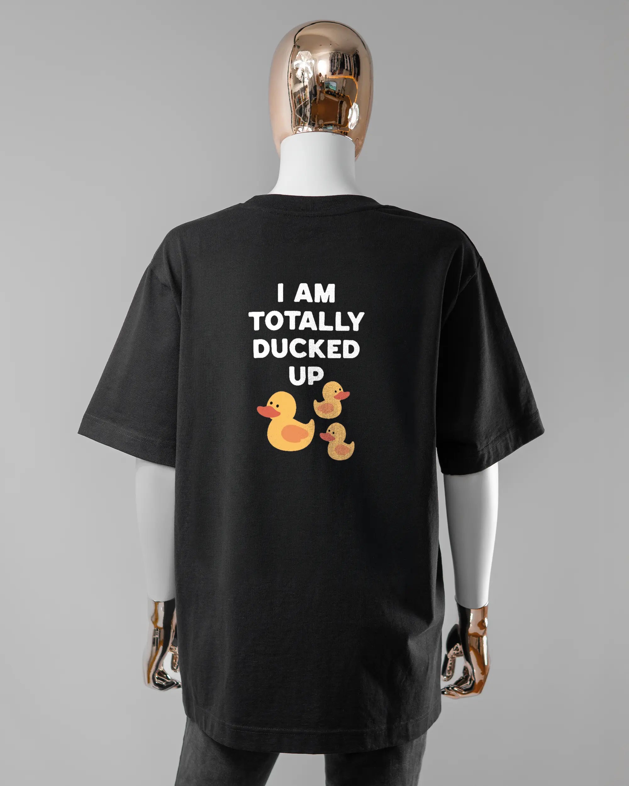 Rückseite des Organic Unisex T-Shirt Heavy Oversized von Maondo mit dem Design Ducked Up in der Farbe Black und in der Größe S getragen von einer femininen Puppe