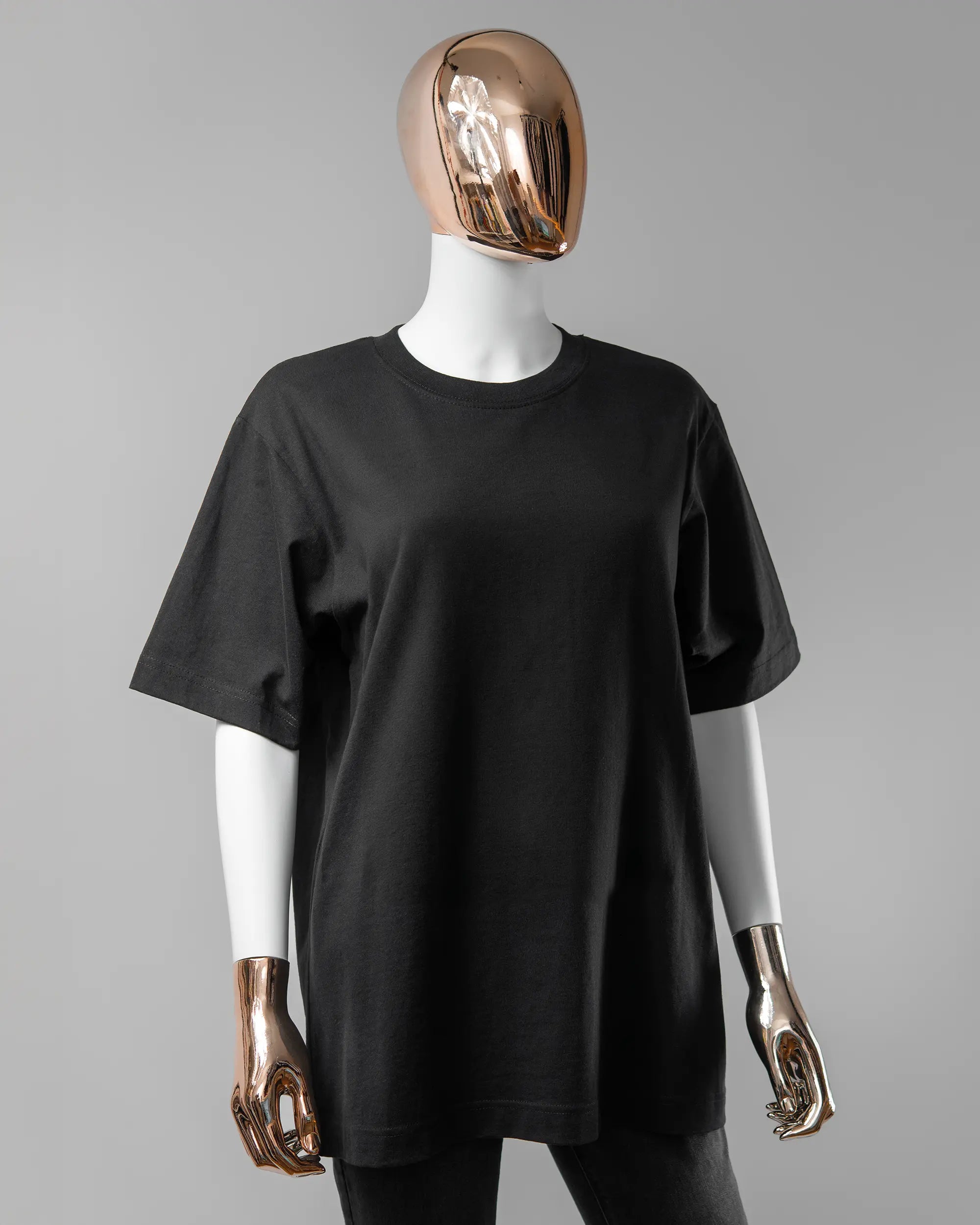 Vorderseite des Organic Unisex T-Shirt Heavy Oversized von Maondo ohne Motiv in der Farbe Black und in der Größe S getragen von einer femininen Puppe