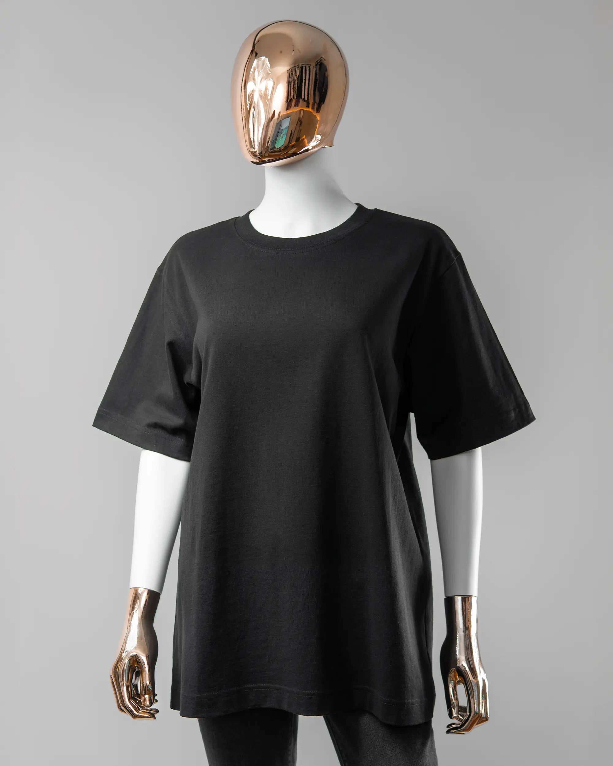 Vorderseite des Organic Unisex T-Shirt Heavy Oversized von Maondo ohne Motiv in der Farbe Black und in der Größe S getragen von einer femininen Puppe