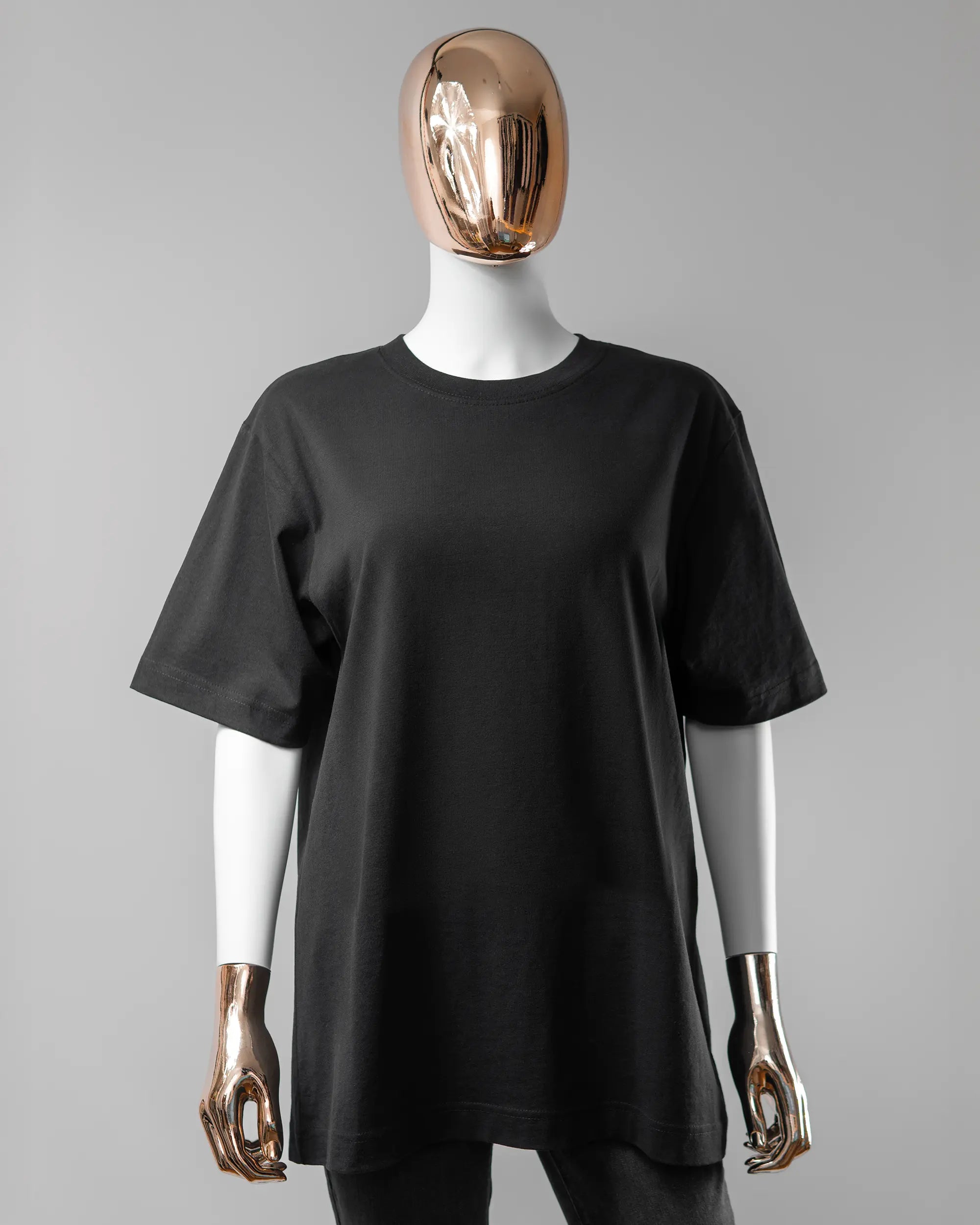 Vorderseite des Organic Unisex T-Shirt Heavy Oversized von Maondo ohne Motiv in der Farbe Black und in der Größe S getragen von einer femininen Puppe