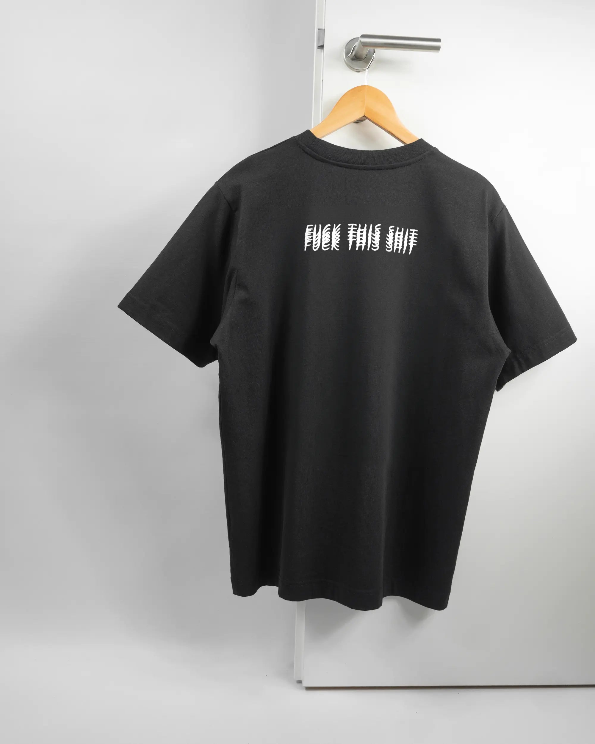 Rückseite des Organic Unisex T-Shirt Heavy Oversized von Maondo mit dem Design Hidden Message in der Farbe Black und in der Größe S auf einem Bügel an der Türklinke aufgehängt