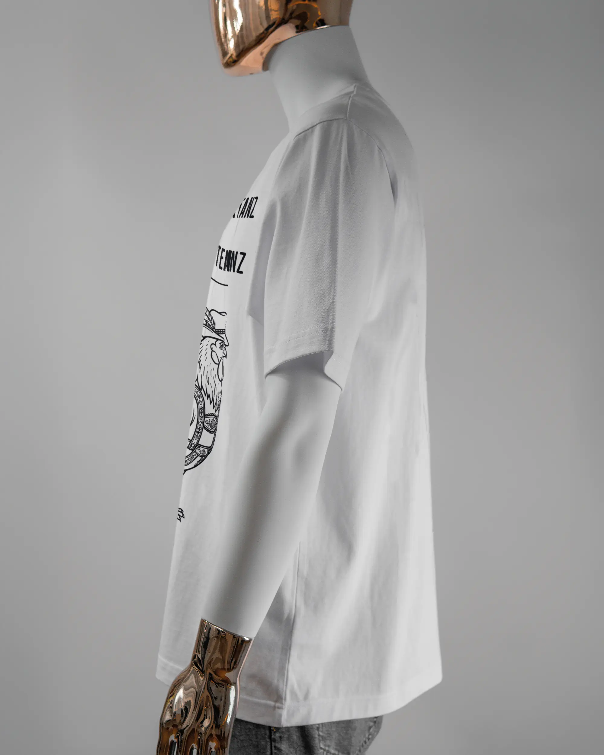 Seitenansicht des Organic Unisex T-Shirt Heavy Oversized von Maondo mit dem Design Trachtentanz vorne in der Farbe White und in der Größe L getragen von einer maskulinen Puppe