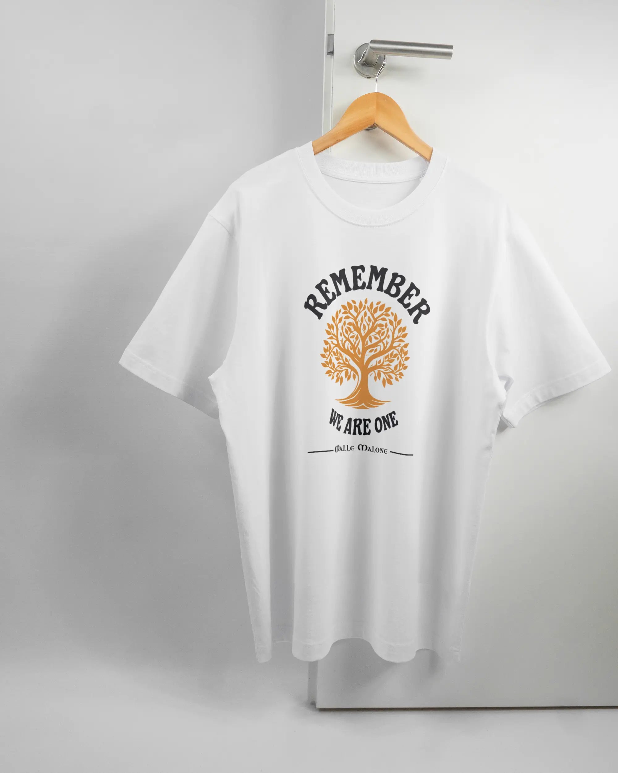 Vorderseite des Organic Unisex T-Shirt Heavy Oversized von Maondo mit dem Design We are one in der Farbe White und in der Größe L auf einem Bügel an der Türklinke aufgehängt