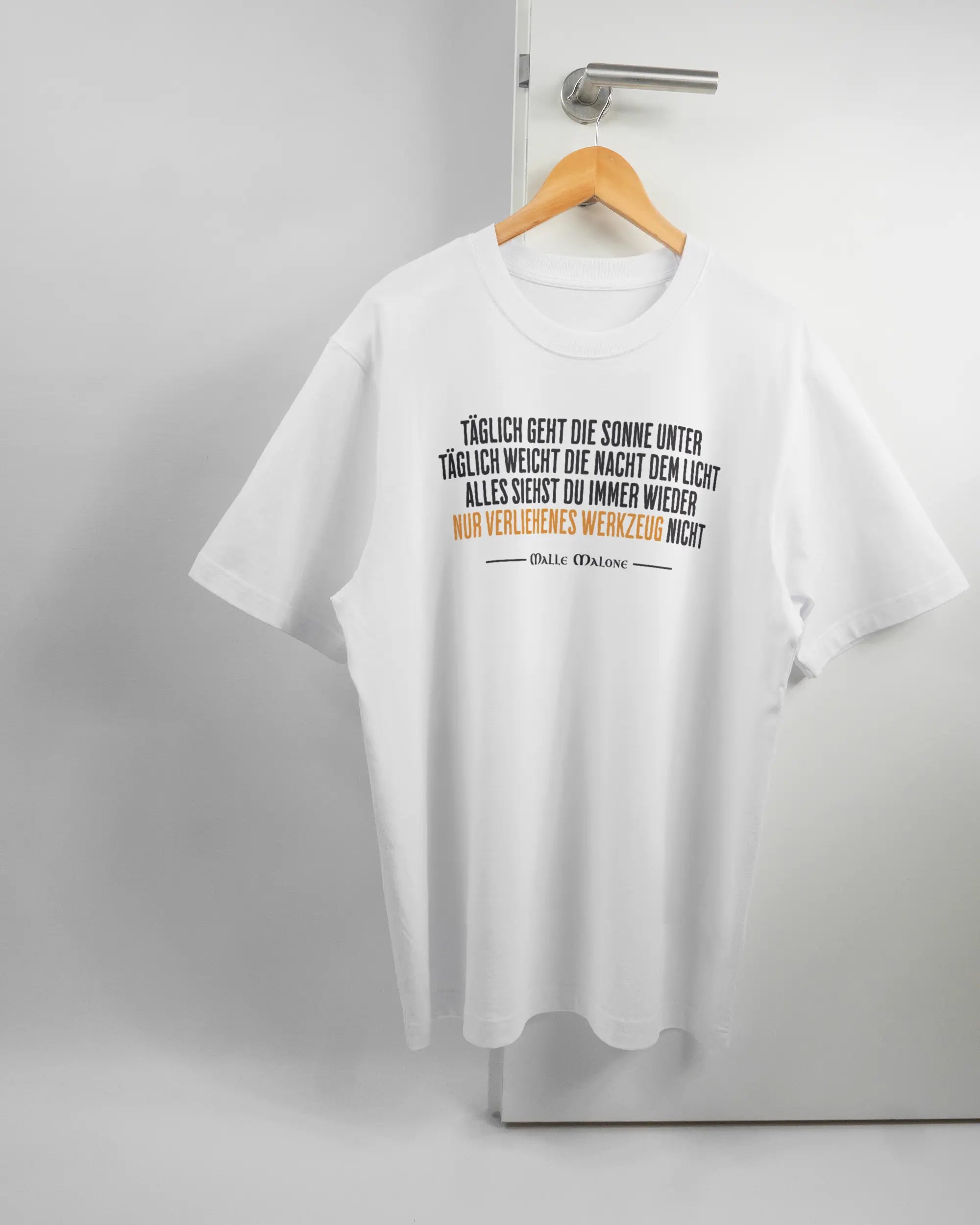 Vorderseite des Organic Unisex T-Shirt Heavy Oversized von Maondo mit dem Design Wegzeug in der Farbe White und in der Größe L auf einem Bügel an der Türklinke aufgehängt