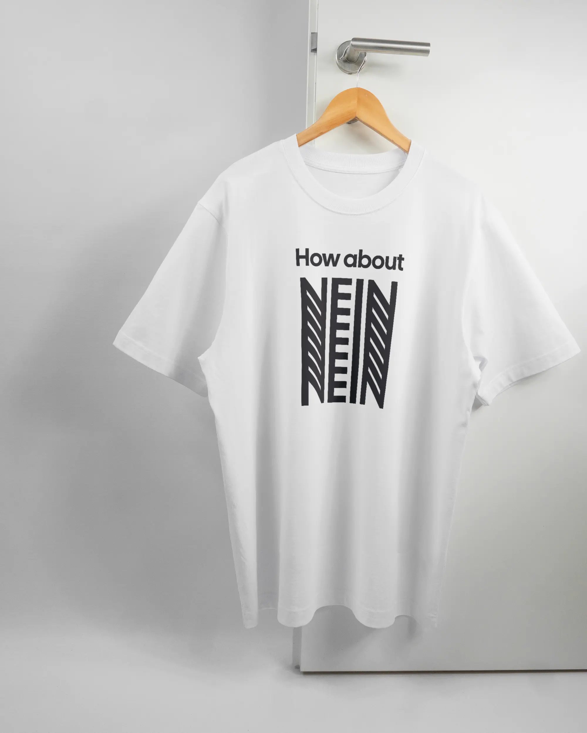Vorderseite des Organic Unisex T-Shirt Heavy Oversized von Maondo mit dem Design How about nein in der Farbe White und in der Größe L auf einem Bügel an der Türklinke aufgehängt