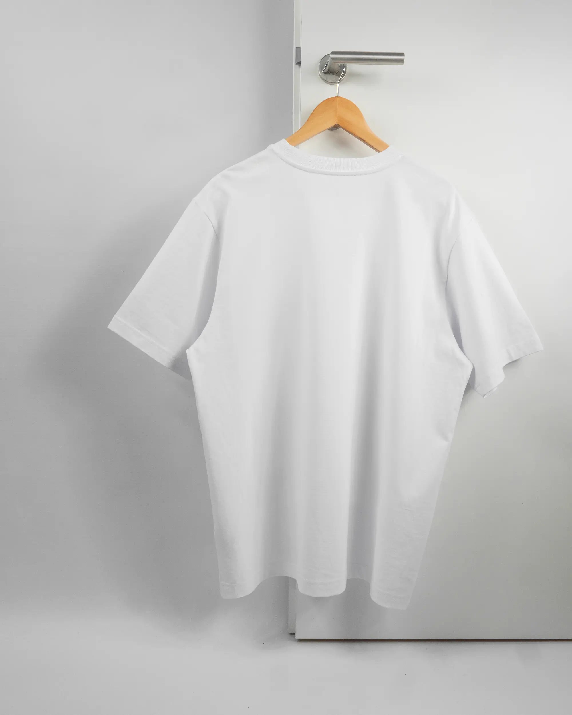 Rückseite des Organic Unisex T-Shirt Heavy Oversized von Maondo ohne Motiv in der Farbe White und in der Größe L auf einem Bügel an der Türklinke aufgehängt