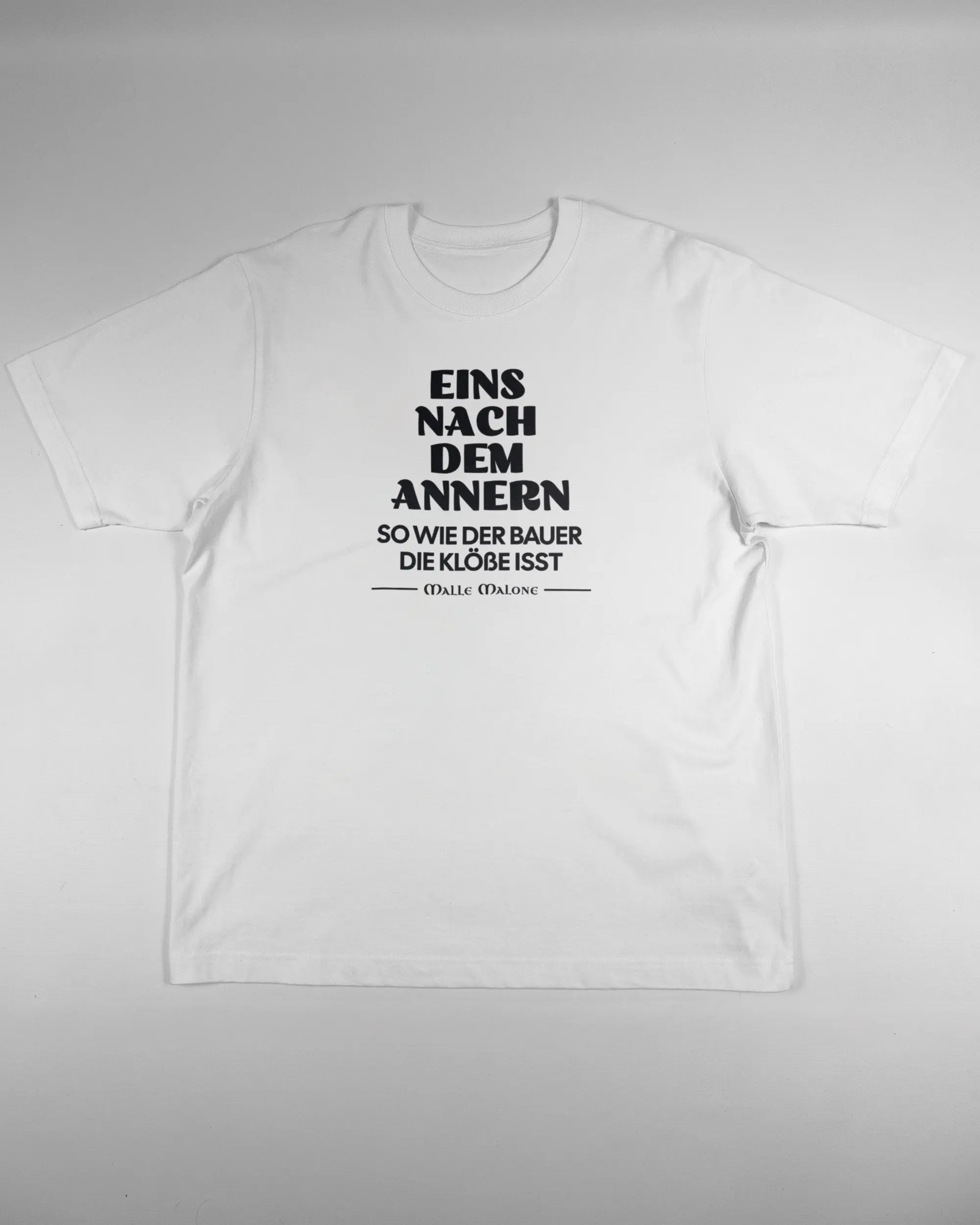 Vorderseite des Organic Unisex T-Shirt Heavy Oversized von Maondo mit dem Design Eins nach dem Annern in der Farbe White und in der Größe L flach auf den Boden gelegt
