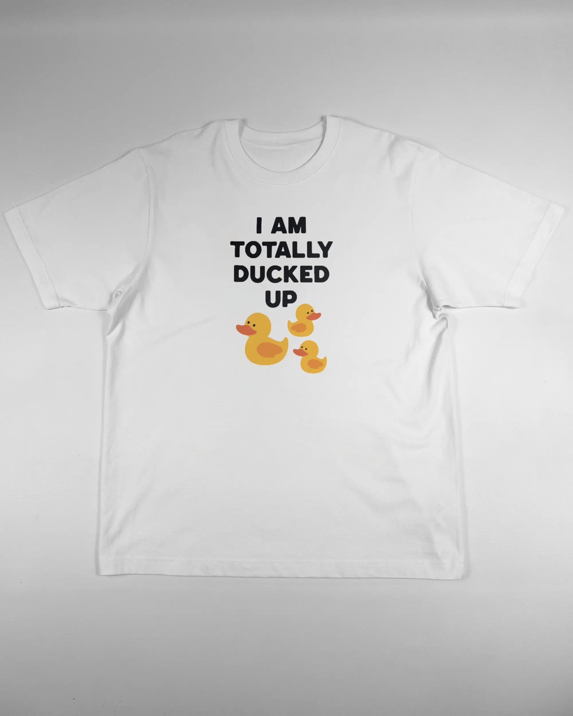 Vorderseite des Organic Unisex T-Shirt Heavy Oversized von Maondo mit dem Design Ducked Up in der Farbe White und in der Größe L flach auf den Boden gelegt