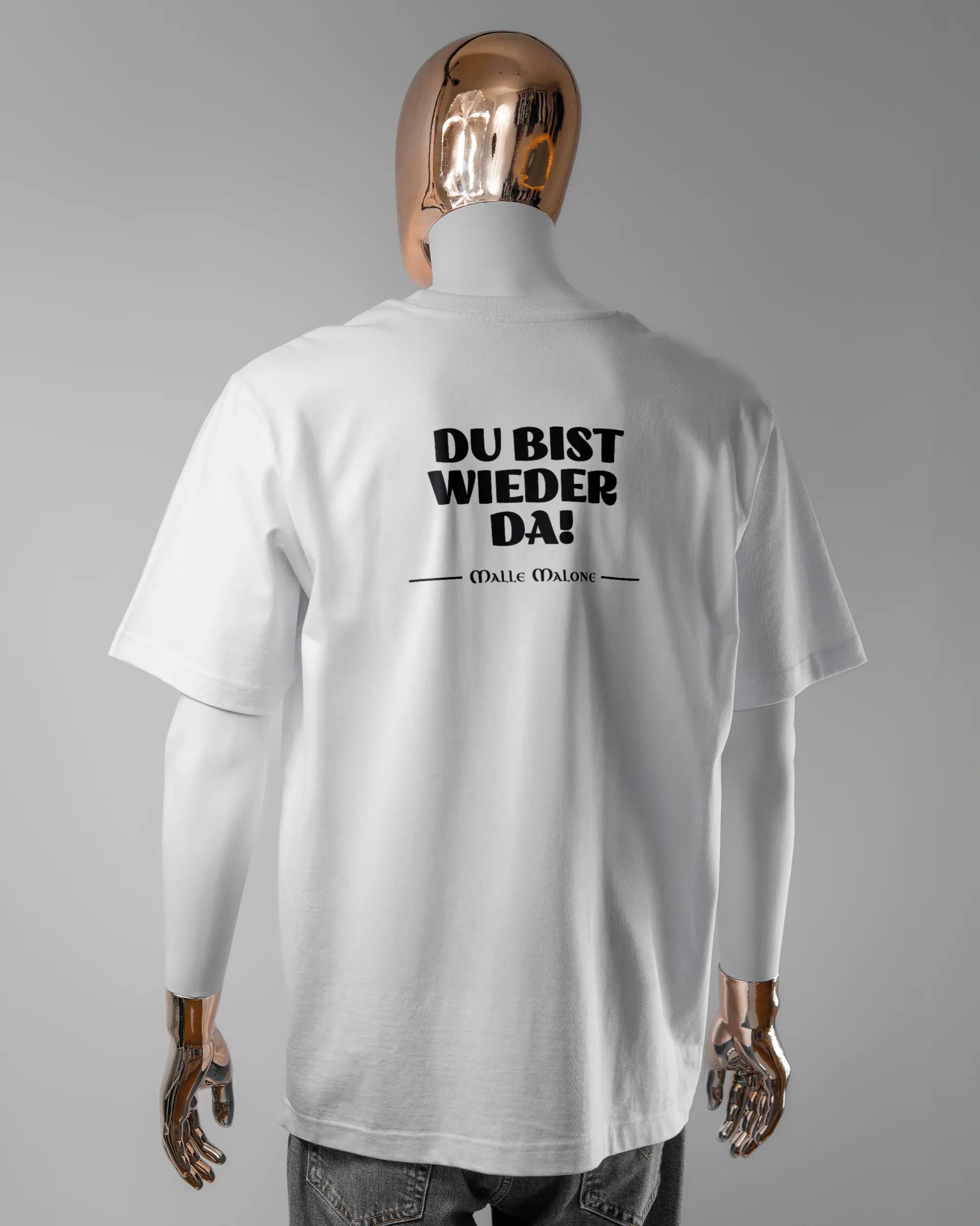 Rückseite des Organic Unisex T-Shirt Heavy Oversized von Maondo mit dem Design Wieder da in der Farbe White und in der Größe L getragen von einer maskulinen Puppe