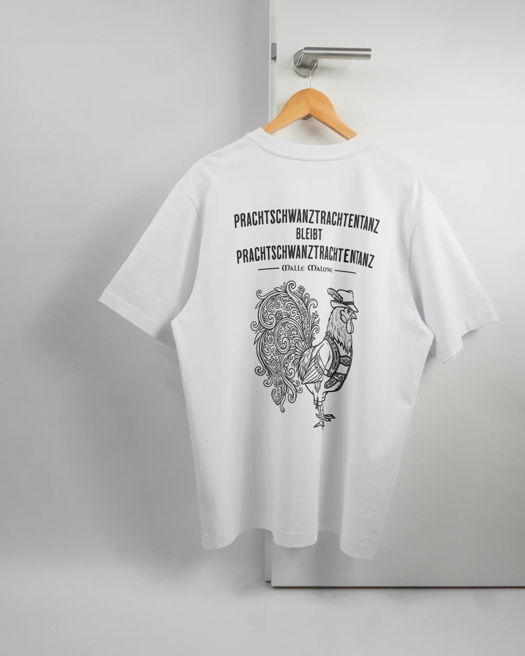 Rückseite des Organic Unisex T-Shirt Heavy Oversized von Maondo mit dem Design Trachtentanz in der Farbe White und in der Größe L auf einem Bügel an der Türklinke aufgehängt