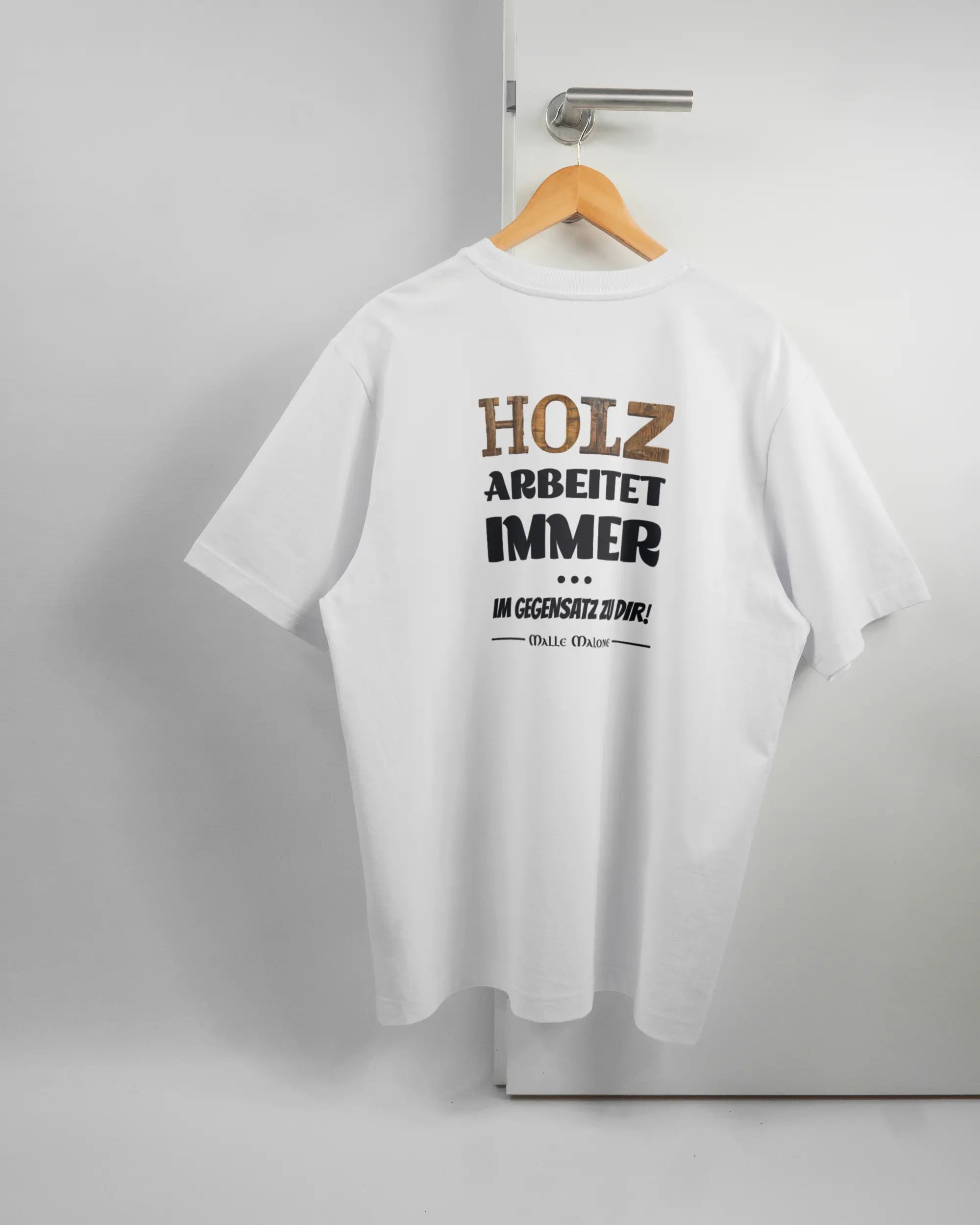 Rückseite des Organic Unisex T-Shirt Heavy Oversized von Maondo mit dem Design Holzarbeit in der Farbe White und in der Größe L auf einem Bügel an der Türklinke aufgehängt