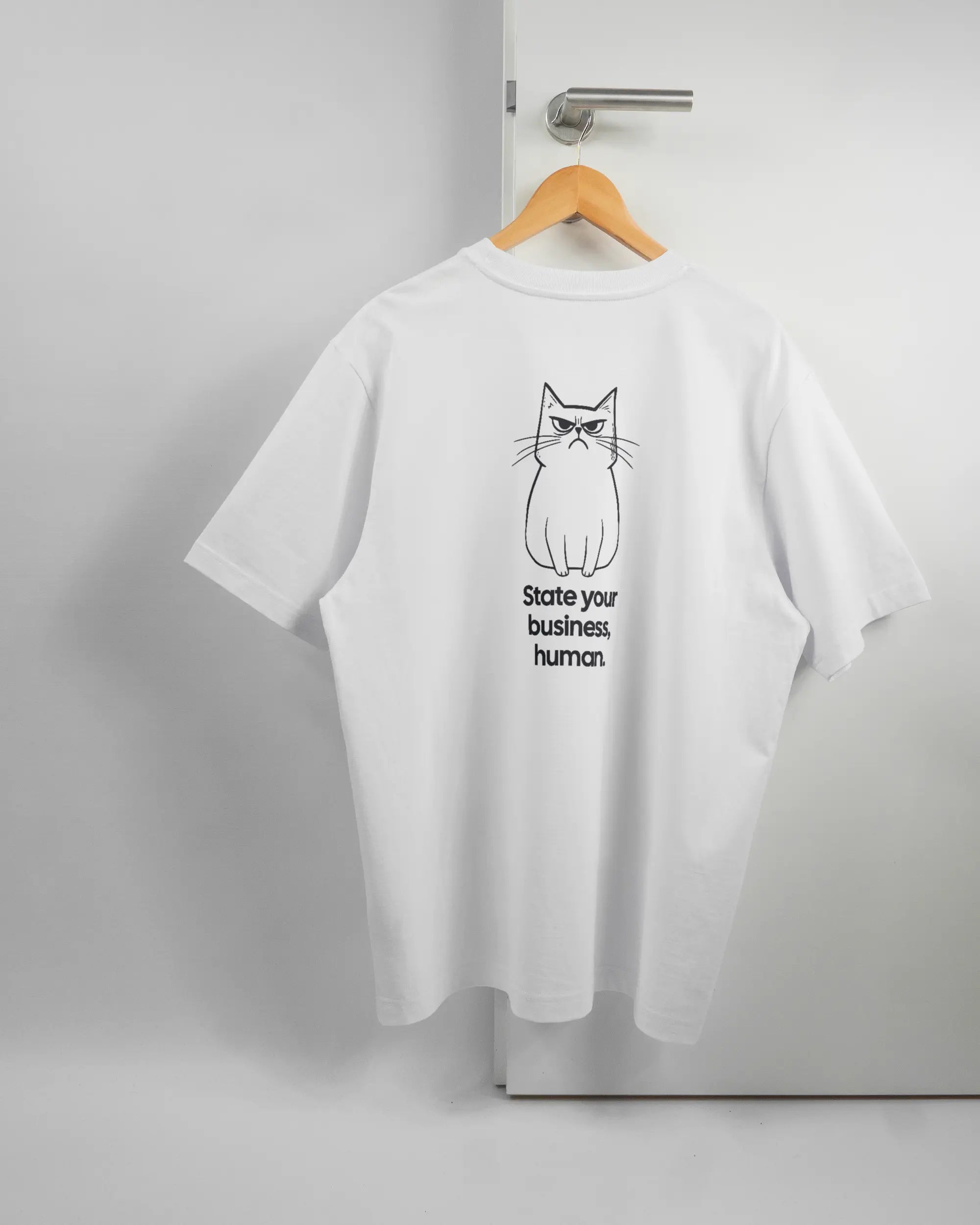 Rückseite des Organic Unisex T-Shirt Heavy Oversized von Maondo mit dem Design Grumpy Purr in der Farbe White und in der Größe L auf einem Bügel an der Türklinke aufgehängt