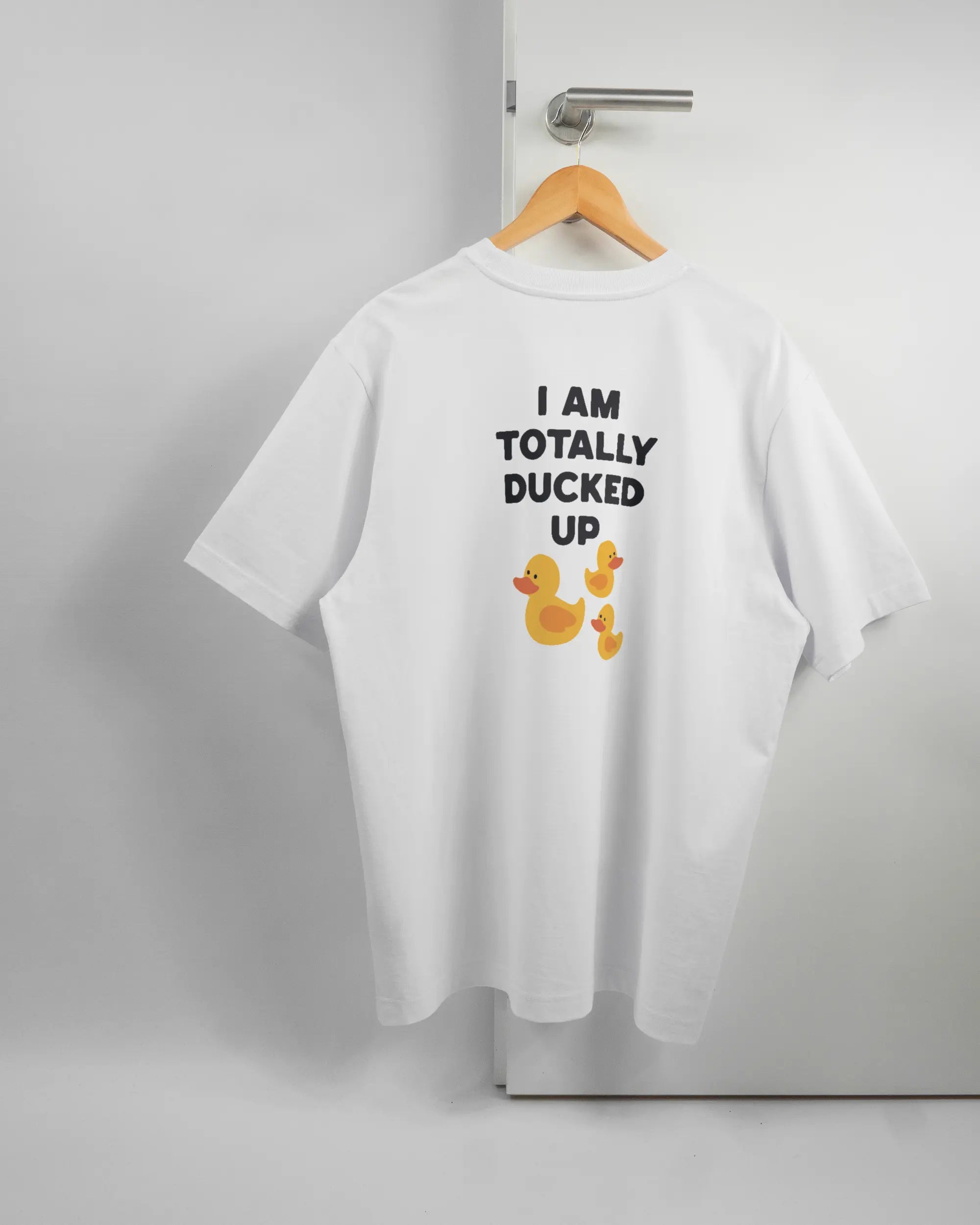 Rückseite des Organic Unisex T-Shirt Heavy Oversized von Maondo mit dem Design Ducked Up in der Farbe White und in der Größe L auf einem Bügel an der Türklinke aufgehängt