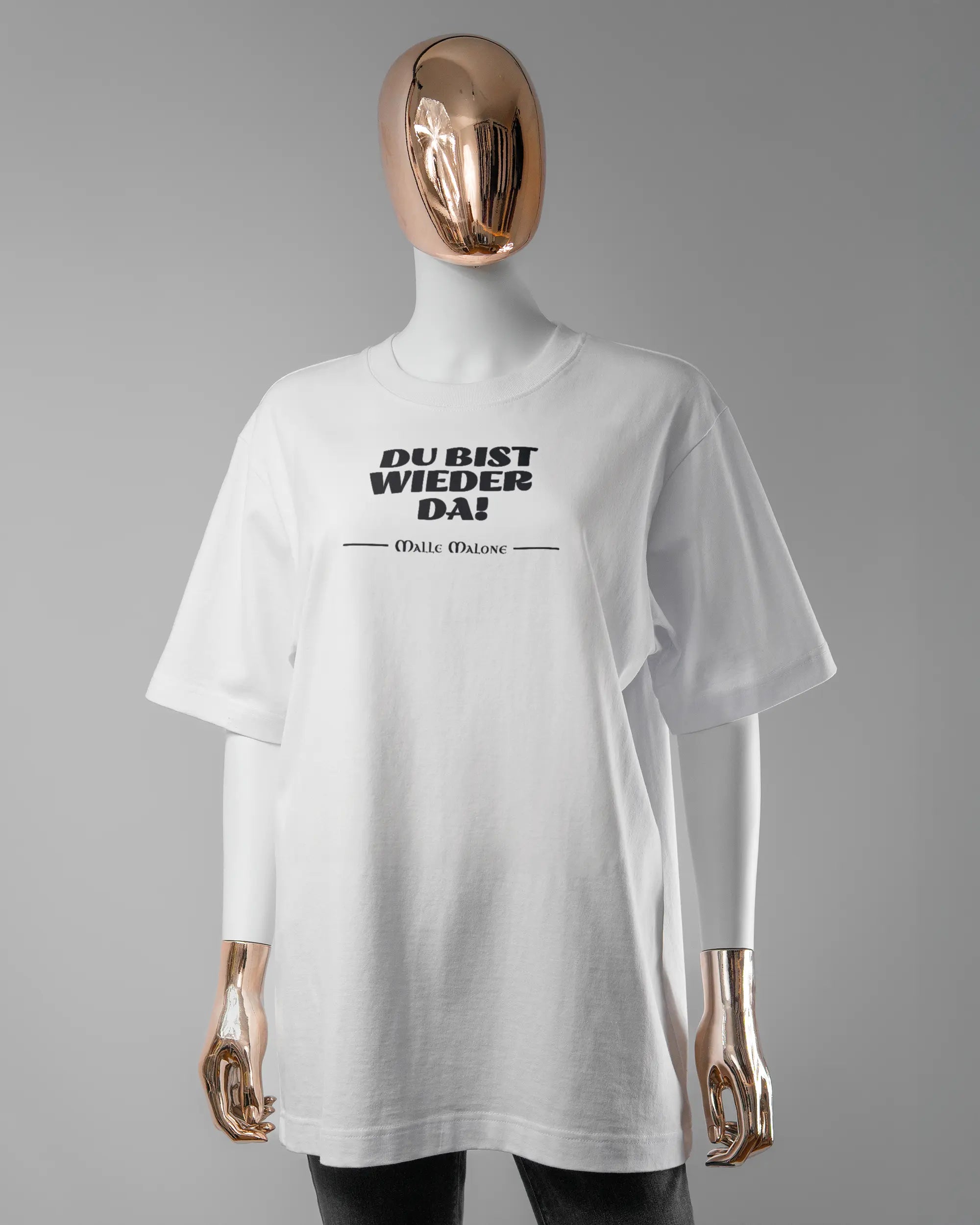 Vorderseite des Organic Unisex T-Shirt Heavy Oversized von Maondo mit dem Design Wieder da in der Farbe White und in der Größe S getragen von einer femininen Puppe