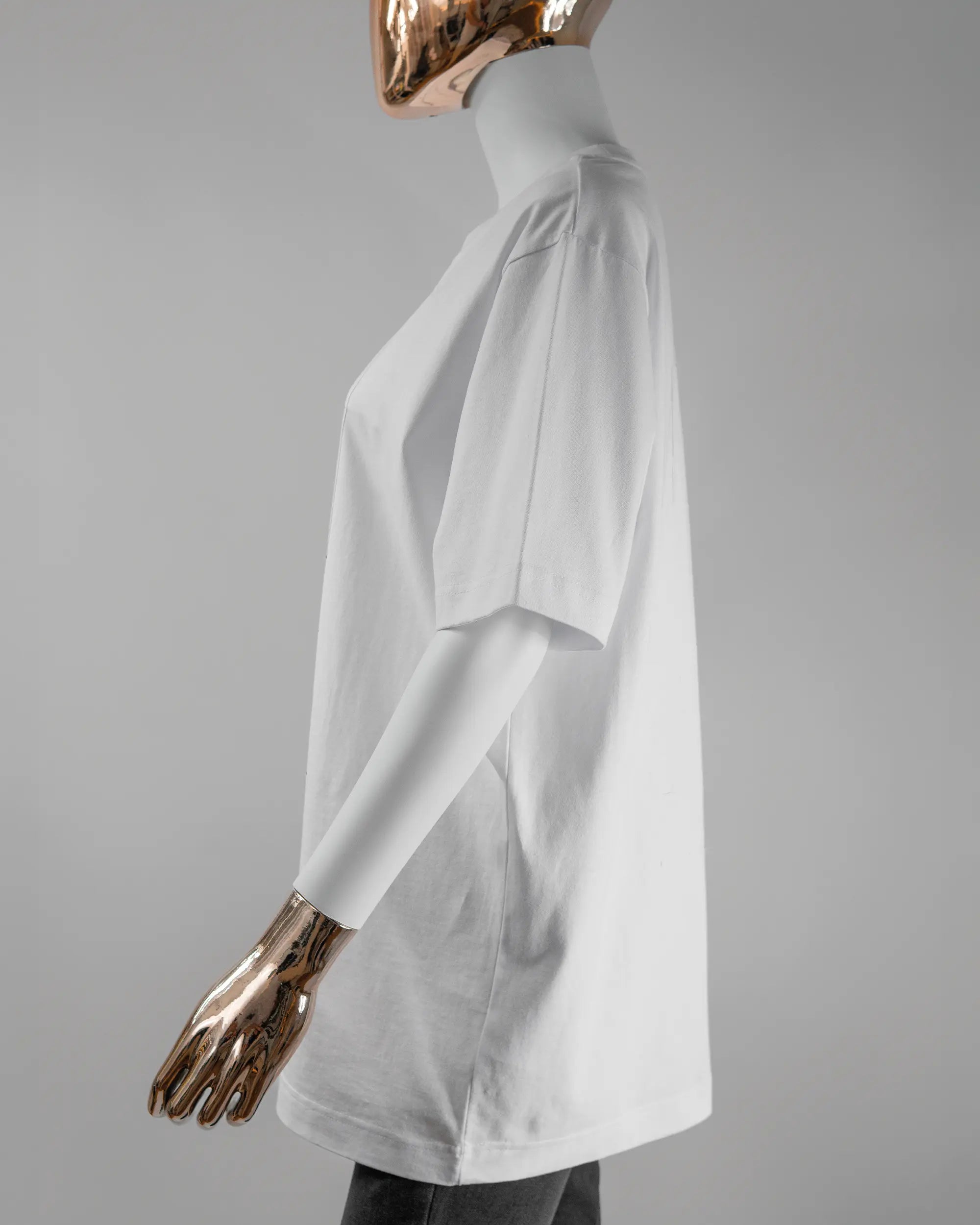 Seitenansicht des Organic Unisex T-Shirt Heavy Oversized von Maondo mit dem Design Holzarbeit vorne in der Farbe White und in der Größe S getragen von einer femininen Puppe