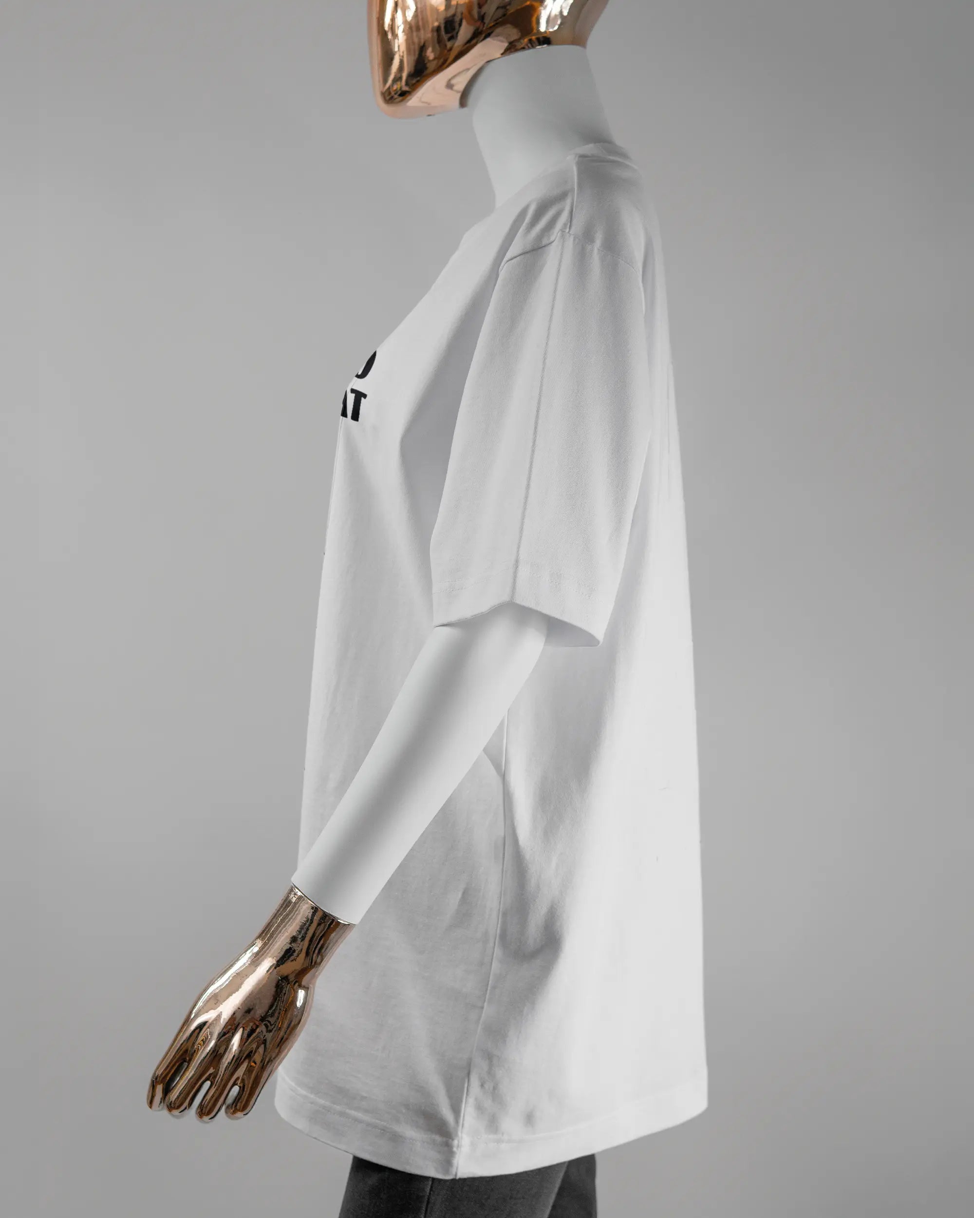 Seitenansicht des Organic Unisex T-Shirt Heavy Oversized von Maondo mit dem Design Keine Eile vorne in der Farbe White und in der Größe S getragen von einer femininen Puppe
