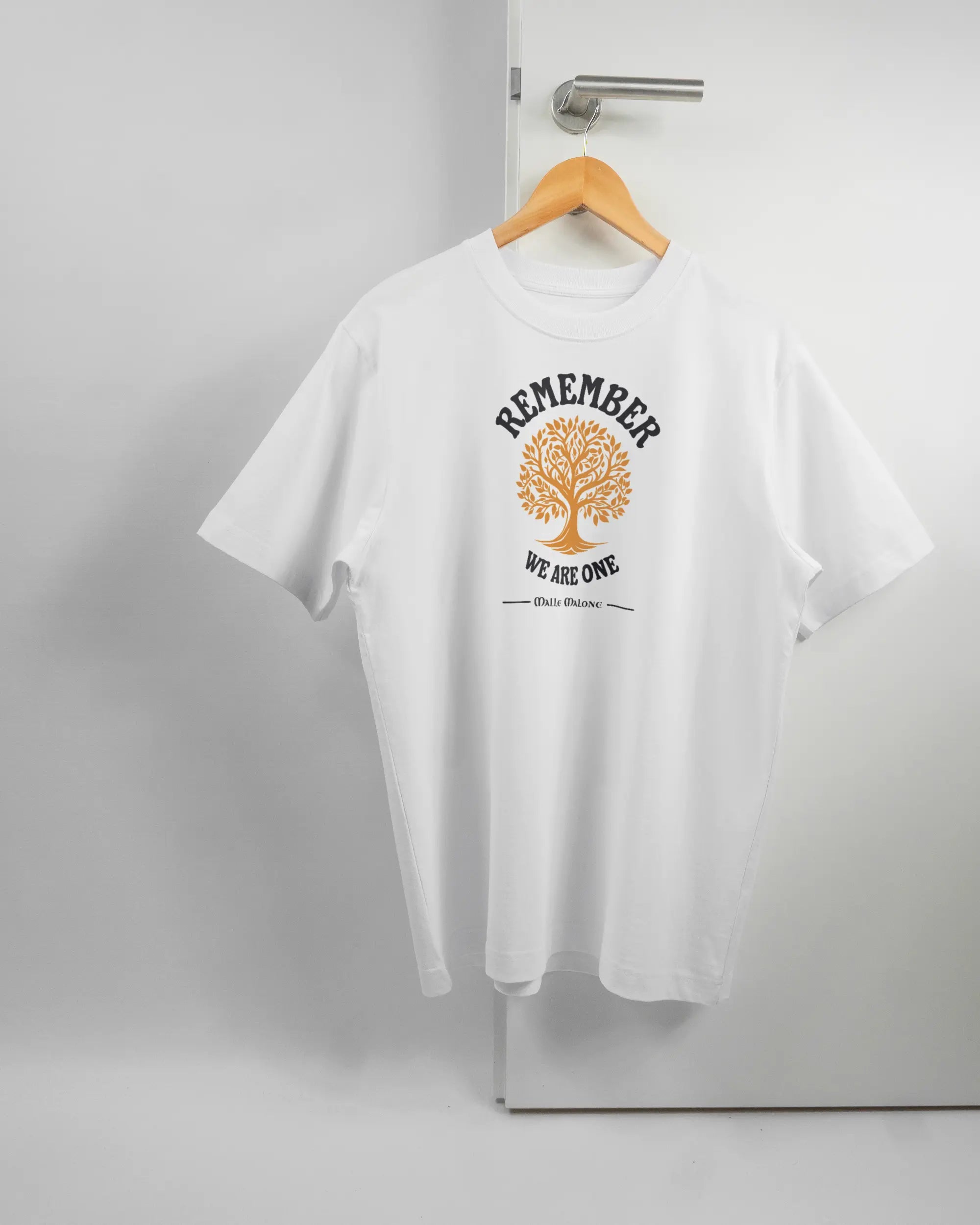 Vorderseite des Organic Unisex T-Shirt Heavy Oversized von Maondo mit dem Design We are one in der Farbe White und in der Größe S auf einem Bügel an der Türklinke aufgehängt