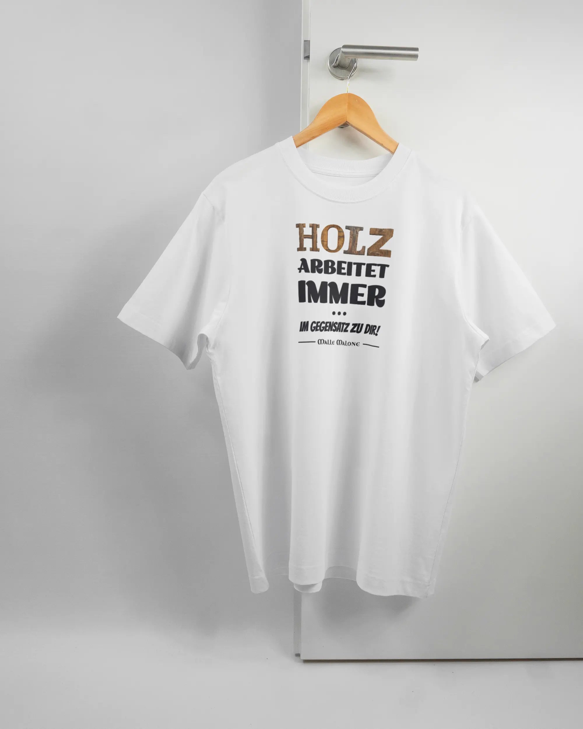 Vorderseite des Organic Unisex T-Shirt Heavy Oversized von Maondo mit dem Design Holzarbeit in der Farbe White und in der Größe S auf einem Bügel an der Türklinke aufgehängt