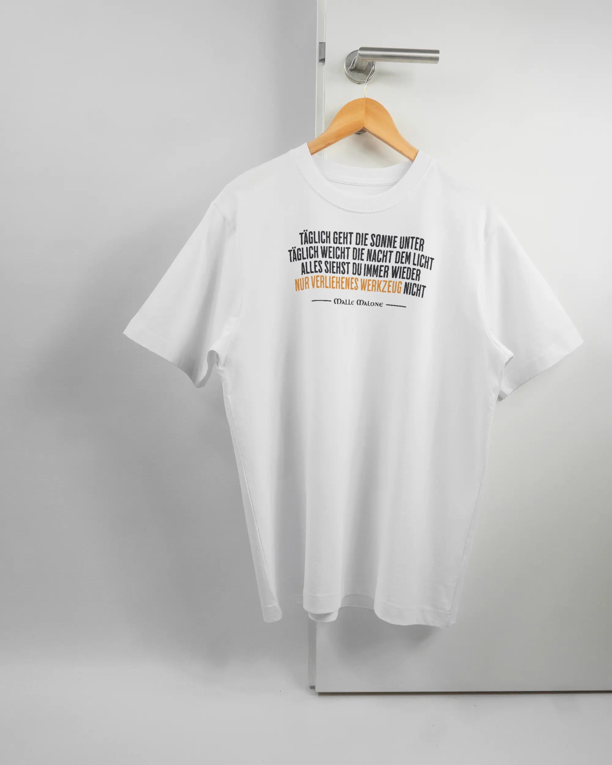 Vorderseite des Organic Unisex T-Shirt Heavy Oversized von Maondo mit dem Design Wegzeug in der Farbe White und in der Größe S auf einem Bügel an der Türklinke aufgehängt
