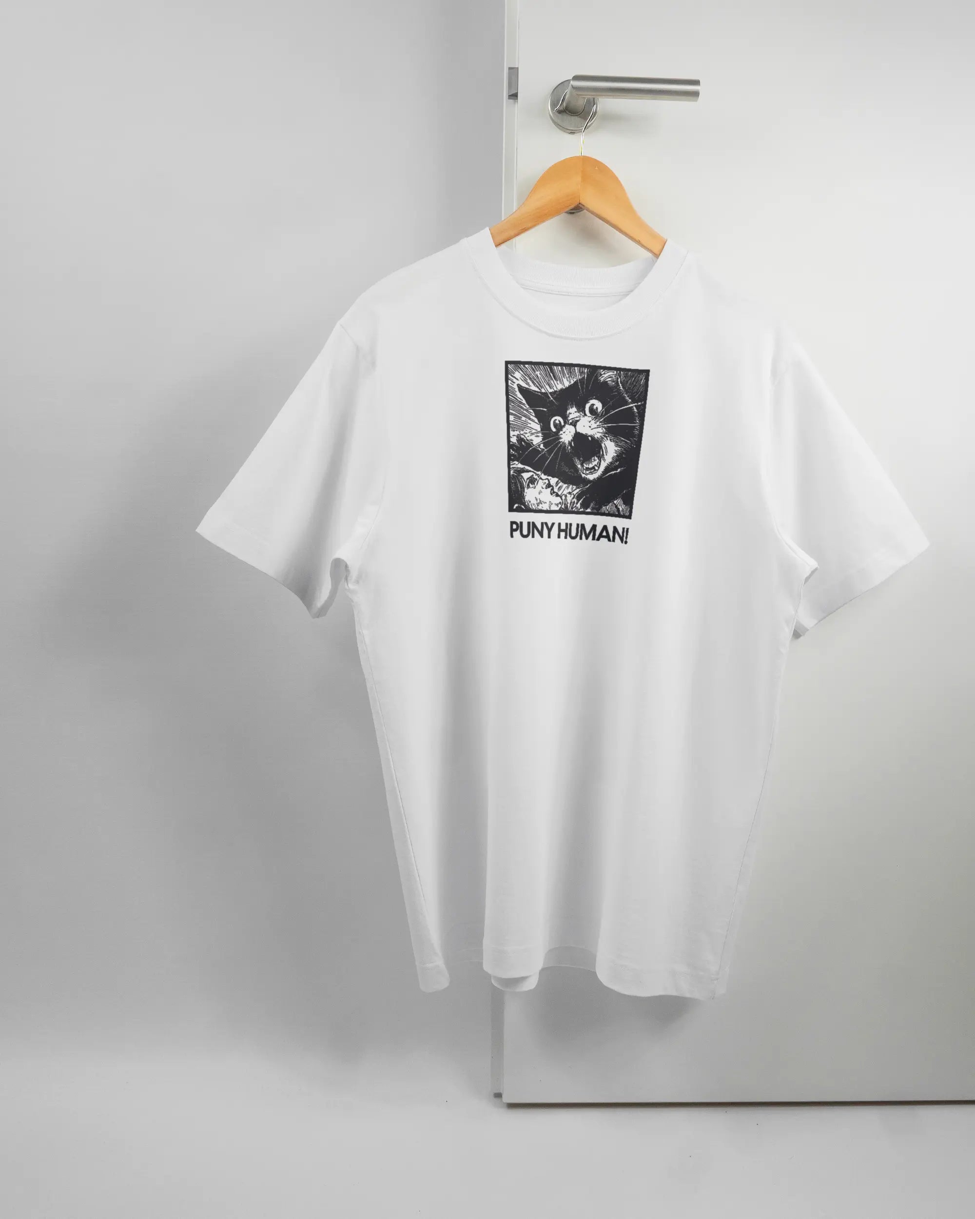 Vorderseite des Organic Unisex T-Shirt Heavy Oversized von Maondo mit dem Design Puny Human in der Farbe White und in der Größe S auf einem Bügel an der Türklinke aufgehängt