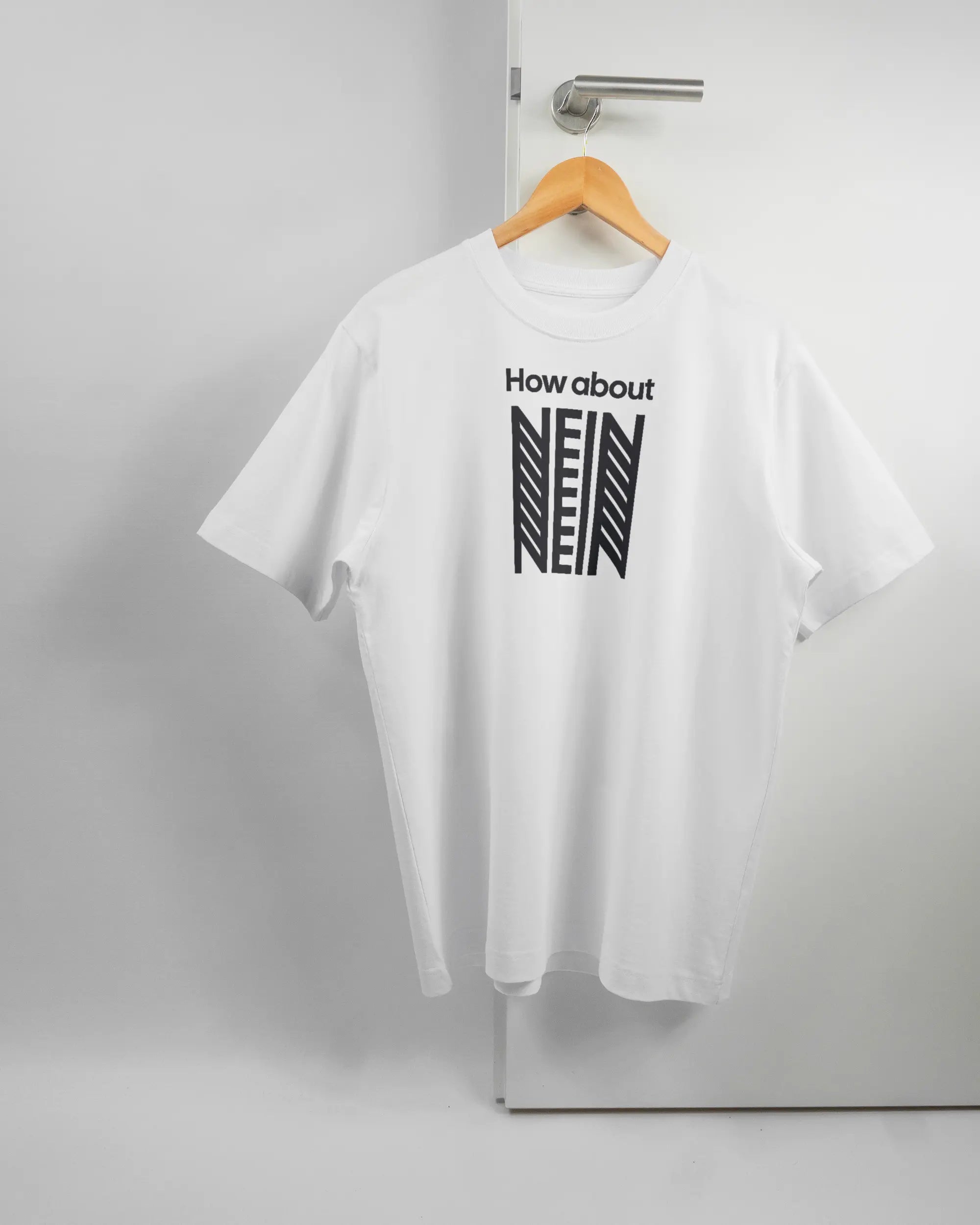 Vorderseite des Organic Unisex T-Shirt Heavy Oversized von Maondo mit dem Design How about nein in der Farbe White und in der Größe S auf einem Bügel an der Türklinke aufgehängt