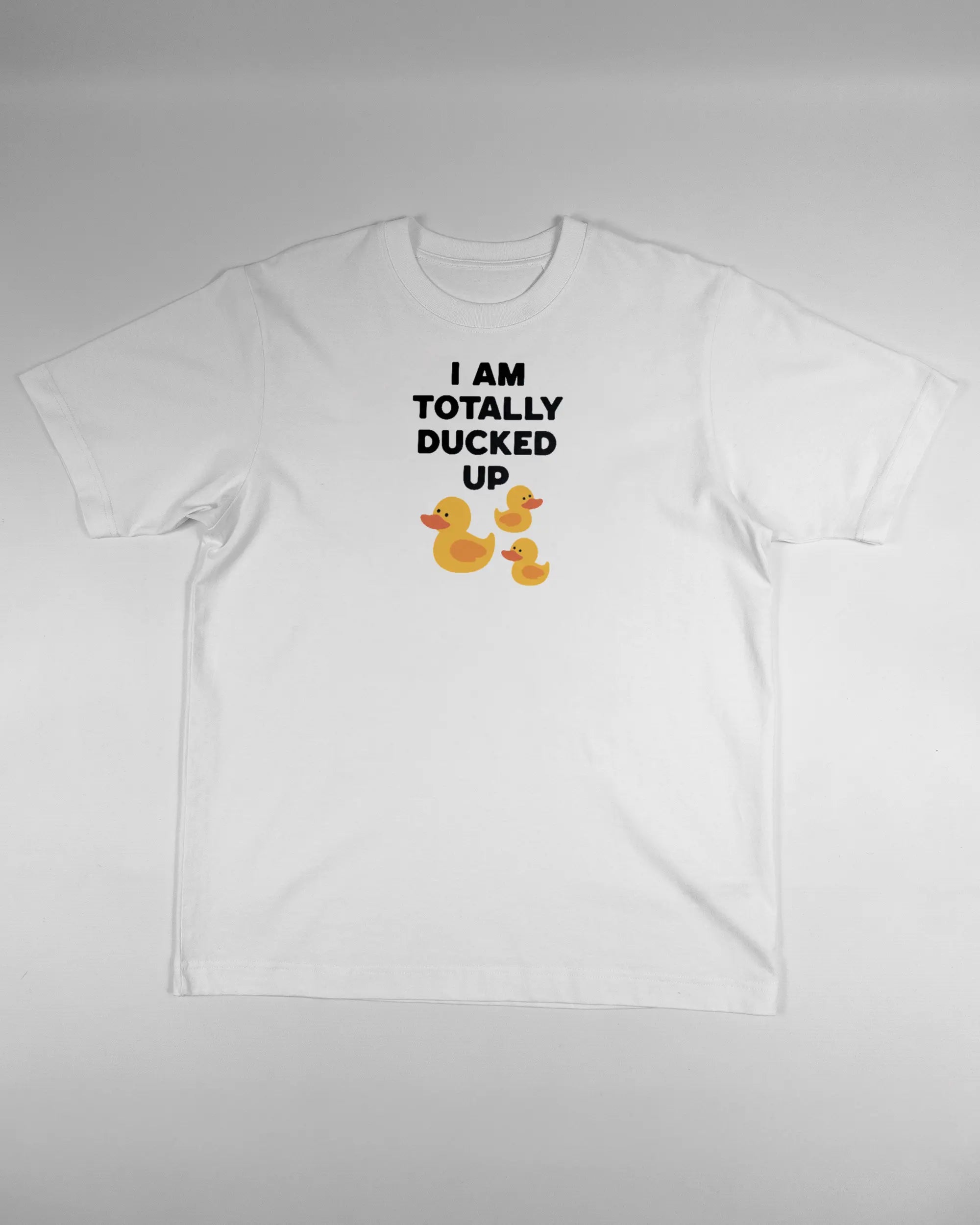 Vorderseite des Organic Unisex T-Shirt Heavy Oversized von Maondo mit dem Design Ducked Up in der Farbe White und in der Größe S flach auf den Boden gelegt