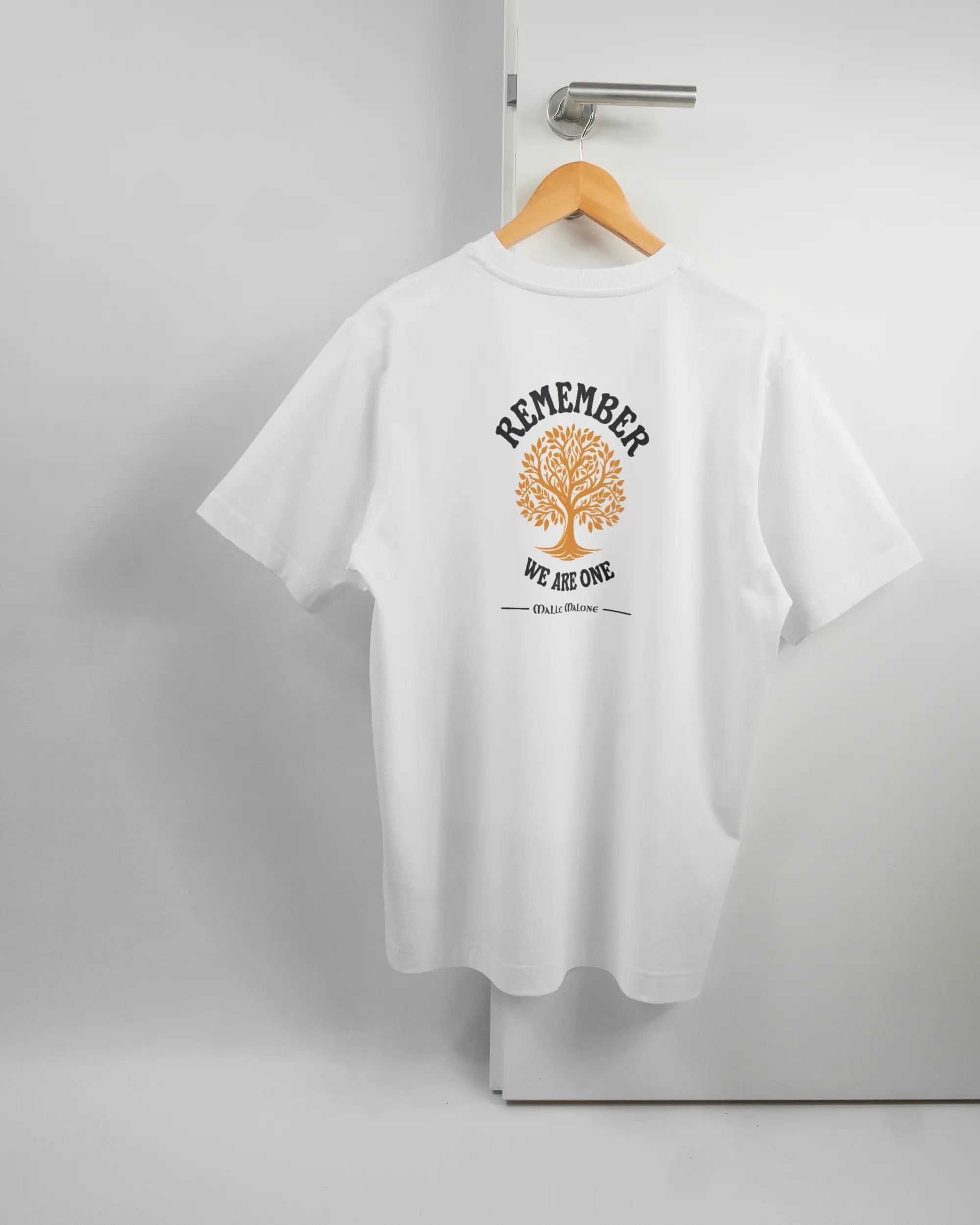 Rückseite des Organic Unisex T-Shirt Heavy Oversized von Maondo mit dem Design We are one in der Farbe White und in der Größe S auf einem Bügel an der Türklinke aufgehängt