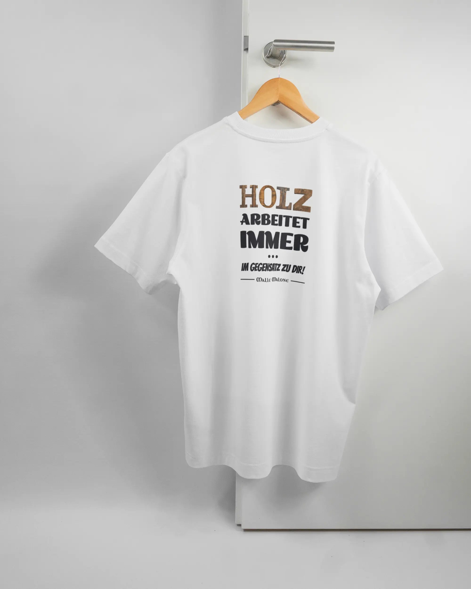 Rückseite des Organic Unisex T-Shirt Heavy Oversized von Maondo mit dem Design Holzarbeit in der Farbe White und in der Größe S auf einem Bügel an der Türklinke aufgehängt